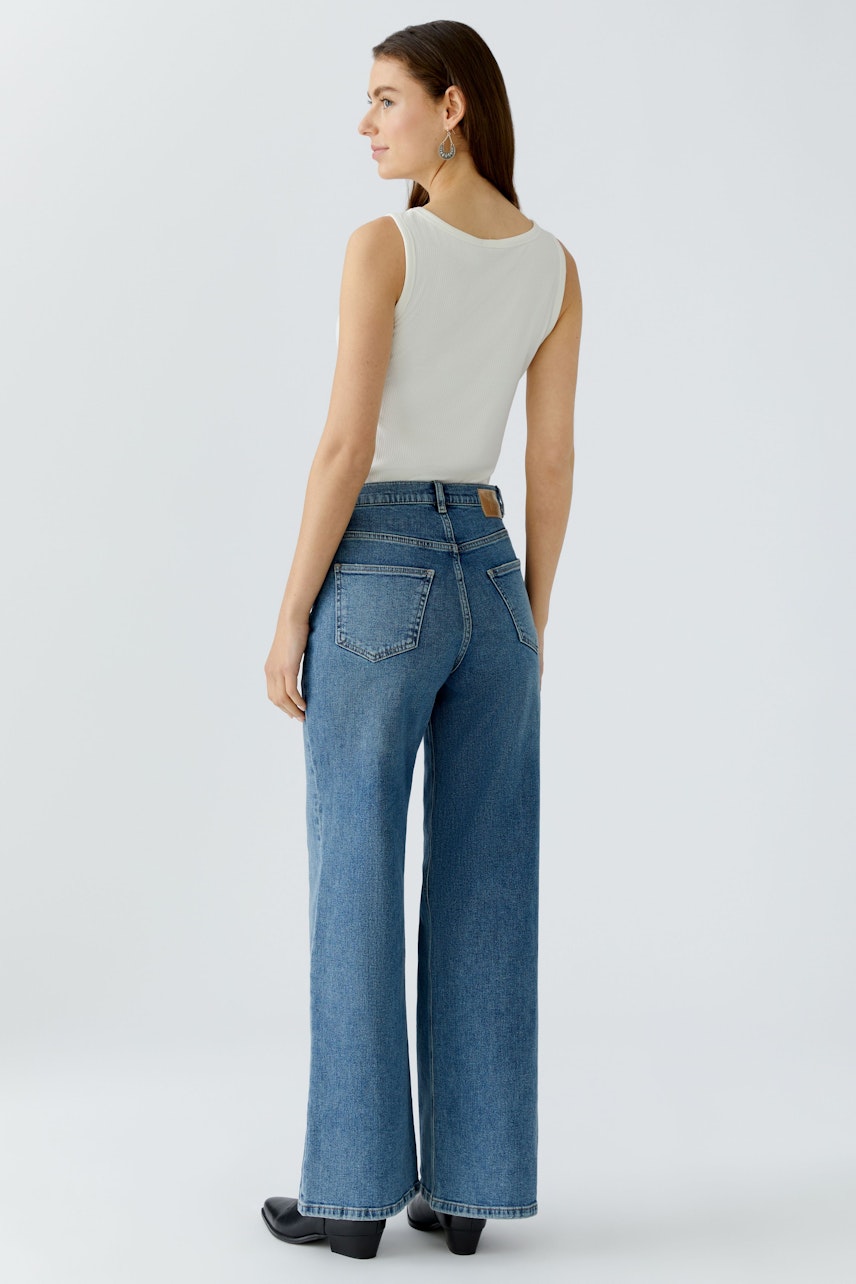 Bequeme 5-Pocket Hose: Frau in lässiger, weiter Jeans mit hohem Bund und klassischem Design.