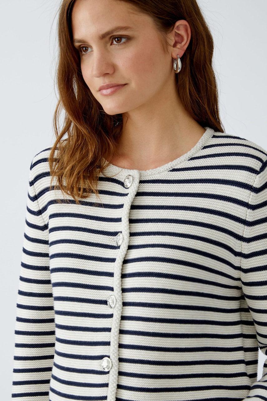Casual women's cardigan: A woman in a striped cardigan with buttons, perfect for layering.