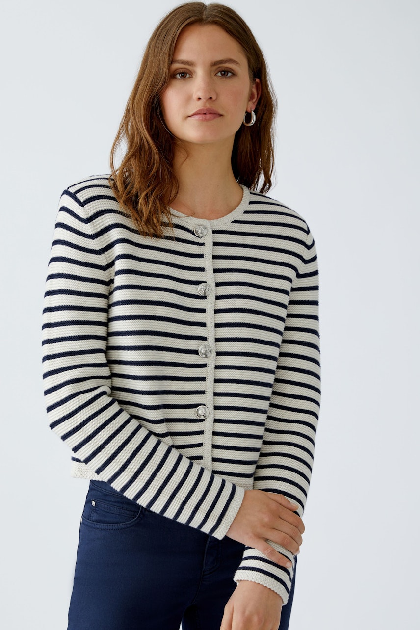Casual women's cardigan: A woman in a striped cardigan with buttons, paired with dark jeans.