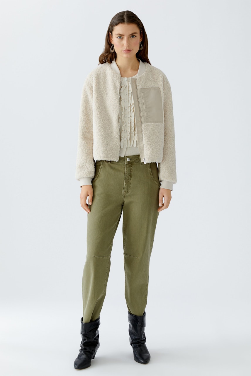 Casual women's blouson: A woman in a cozy cream bomber jacket with a textured finish.