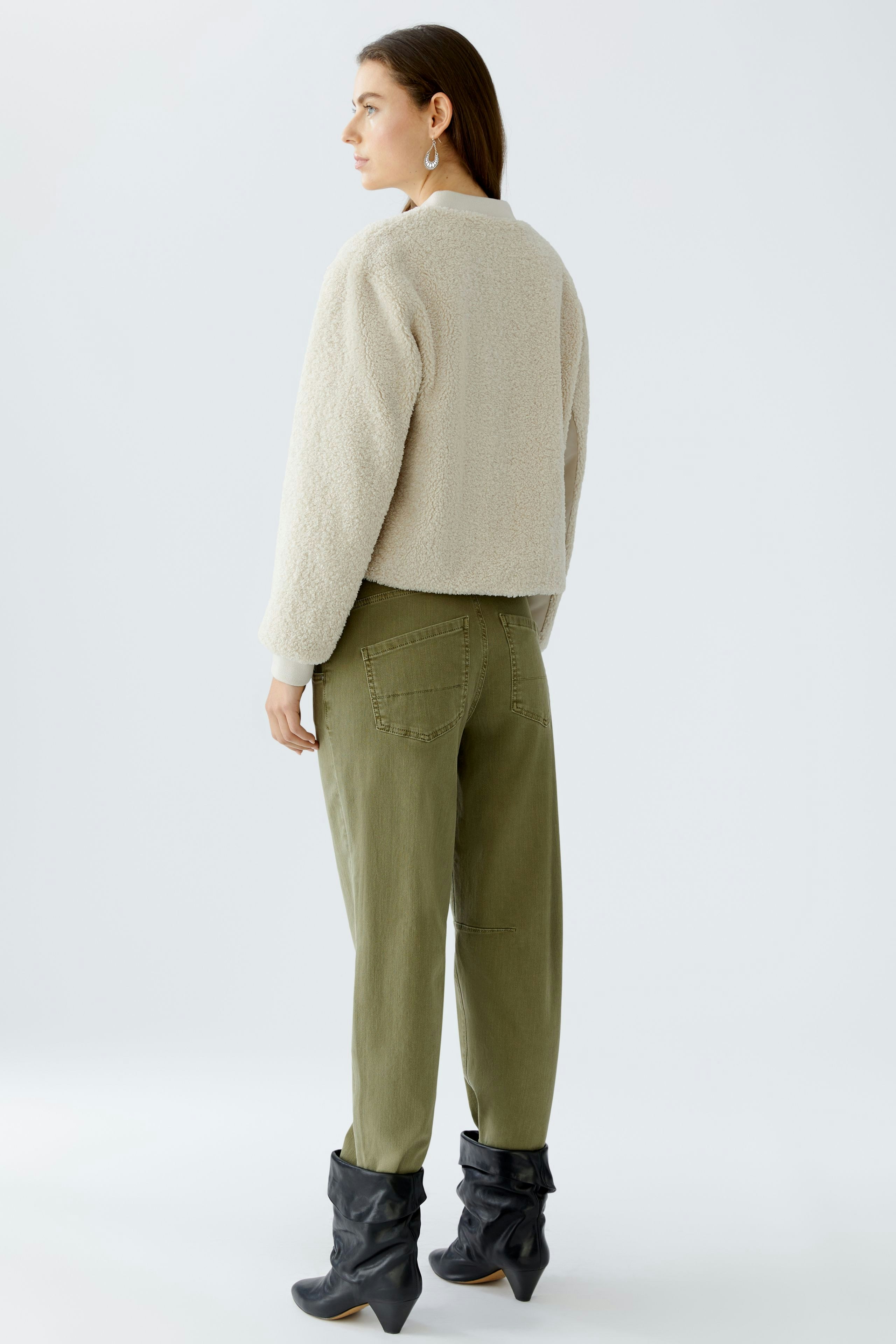 Casual women's blouson: A woman in a cozy beige jacket paired with relaxed olive pants.