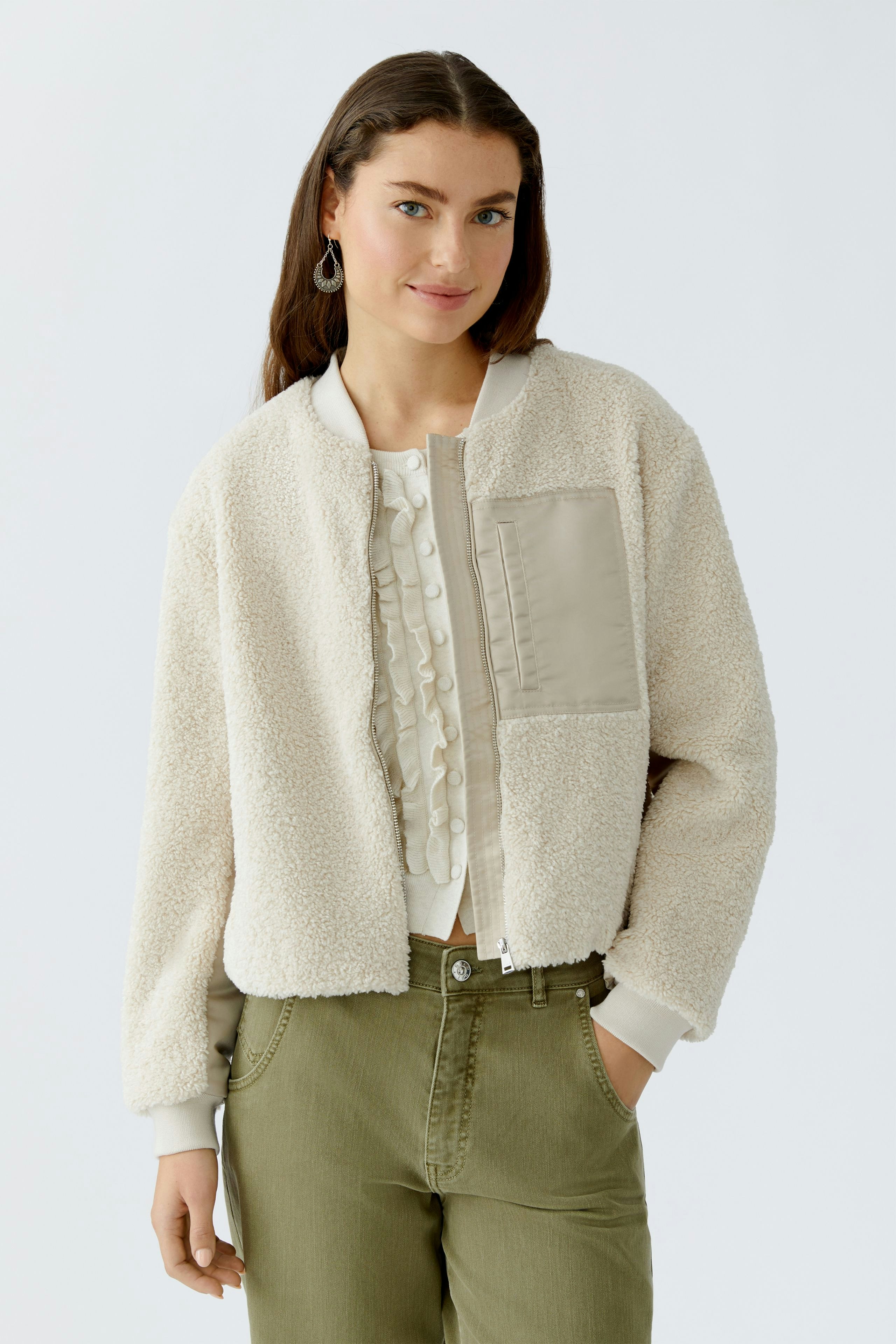 Casual women's blouson: Young woman in a cozy cream bomber jacket with a stylish pocket.
