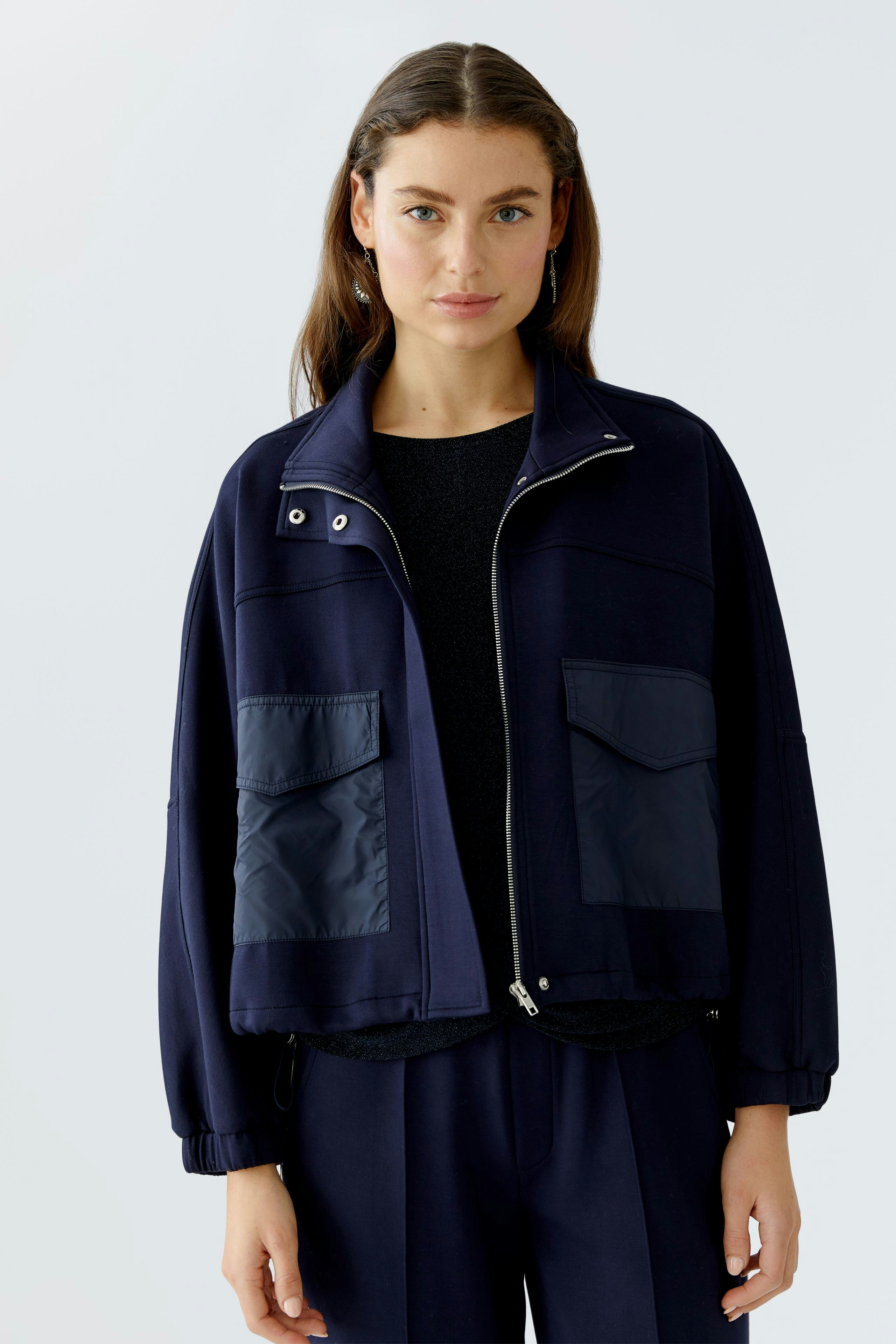 Casual women's jacket: A woman in a navy jacket with large pockets and a relaxed fit.