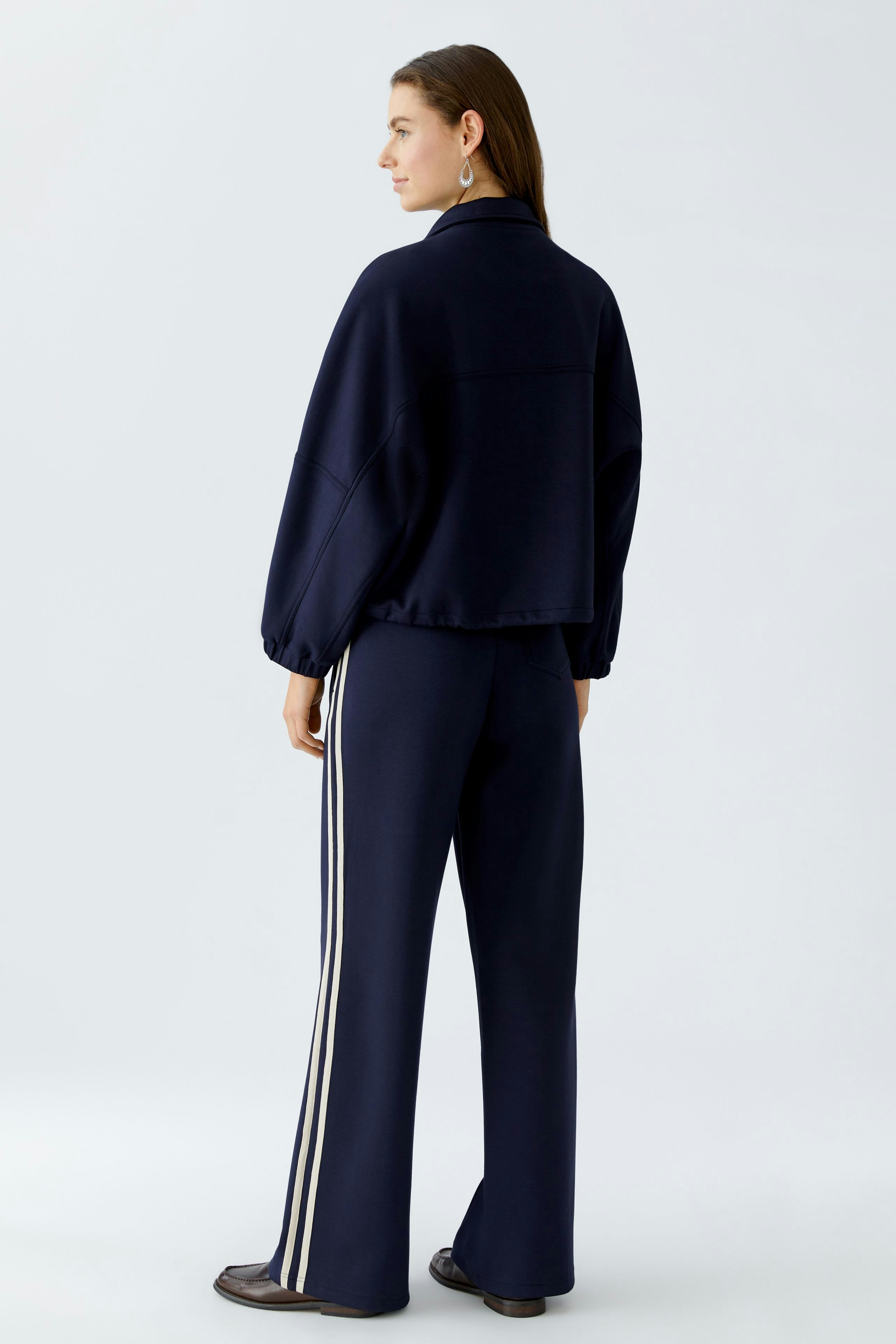 Casual women's jacket: Woman in a navy cropped jacket with a relaxed fit and sporty style.