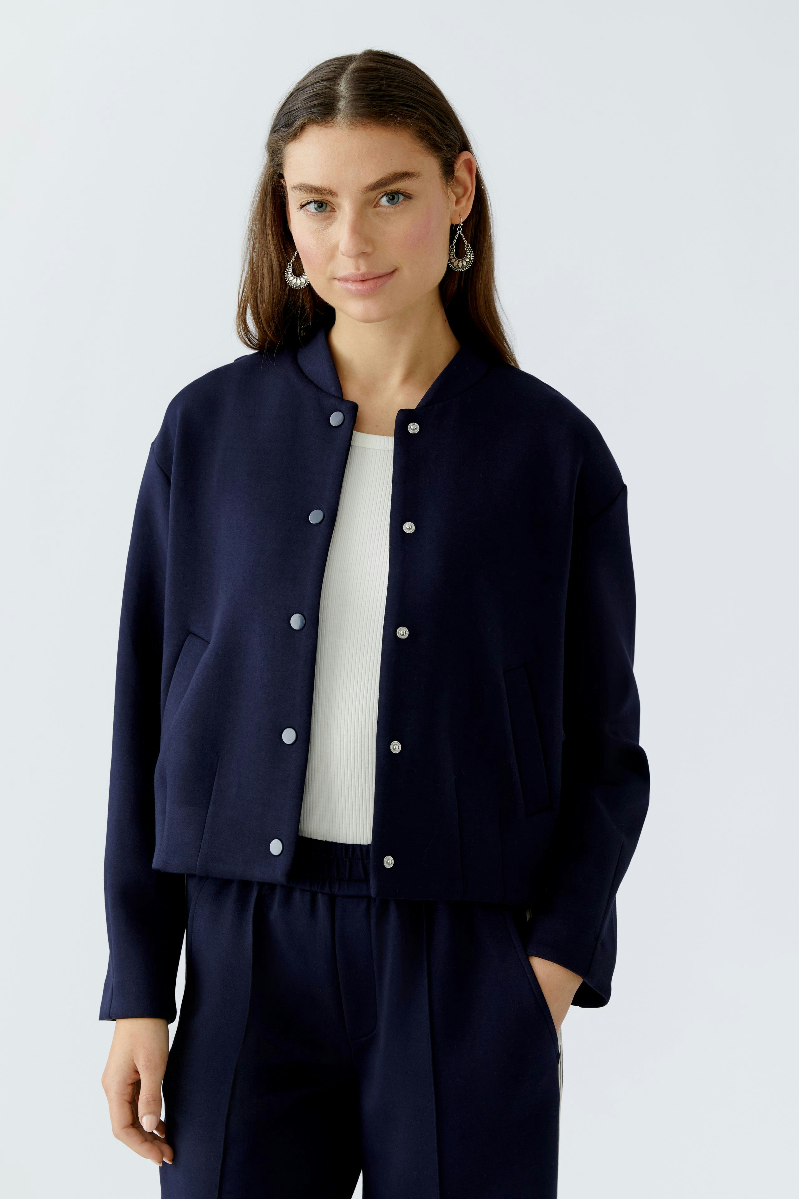 Damen-Blouson: Junge Frau in navy Blouson mit Druckknöpfen und lässigem Look.