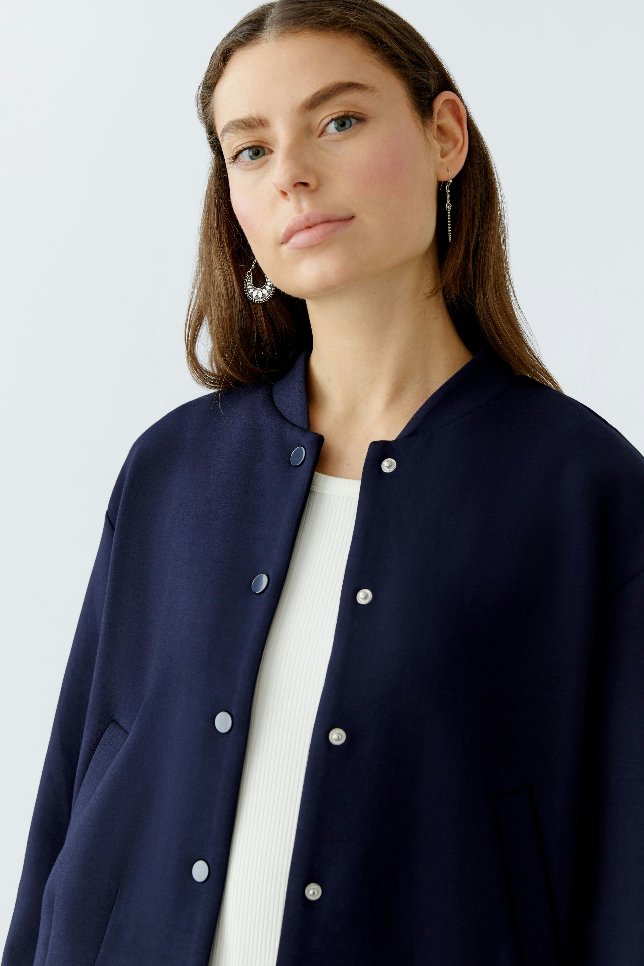 Damen-Blouson: Junge Frau in navy Blouson mit Druckknöpfen und lässigem Look.