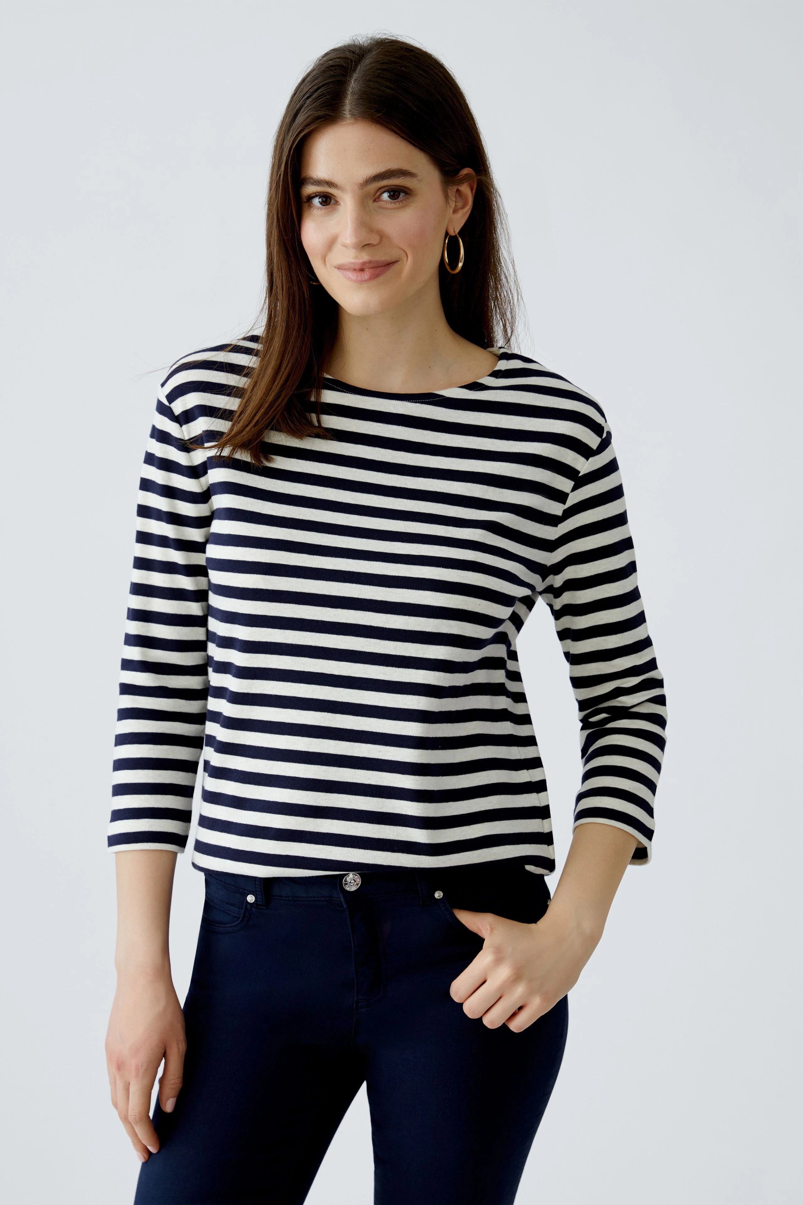 Casual women's T-shirt: Young woman in a striped top with three-quarter sleeves and a relaxed fit.