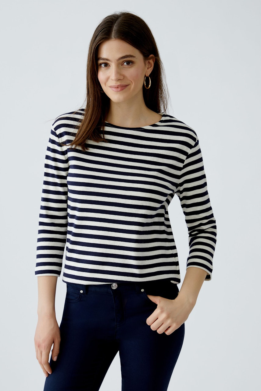 Damen-T-Shirt: Junge Frau in gestreiftem Shirt mit 3/4-Ärmeln und lässiger Ausstrahlung.