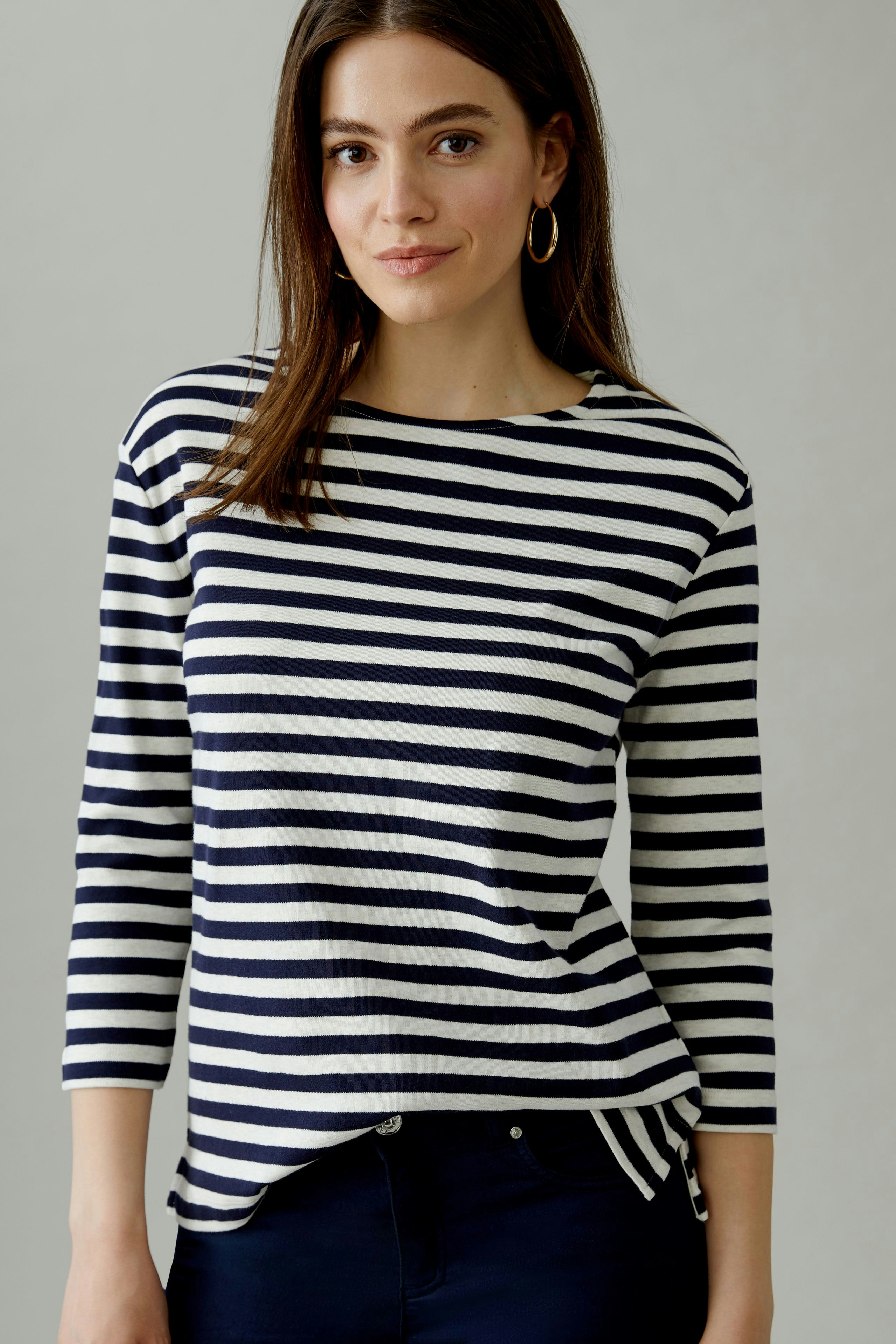 Casual women's T-shirt: Young woman in a striped top with three-quarter sleeves, smiling confidently.