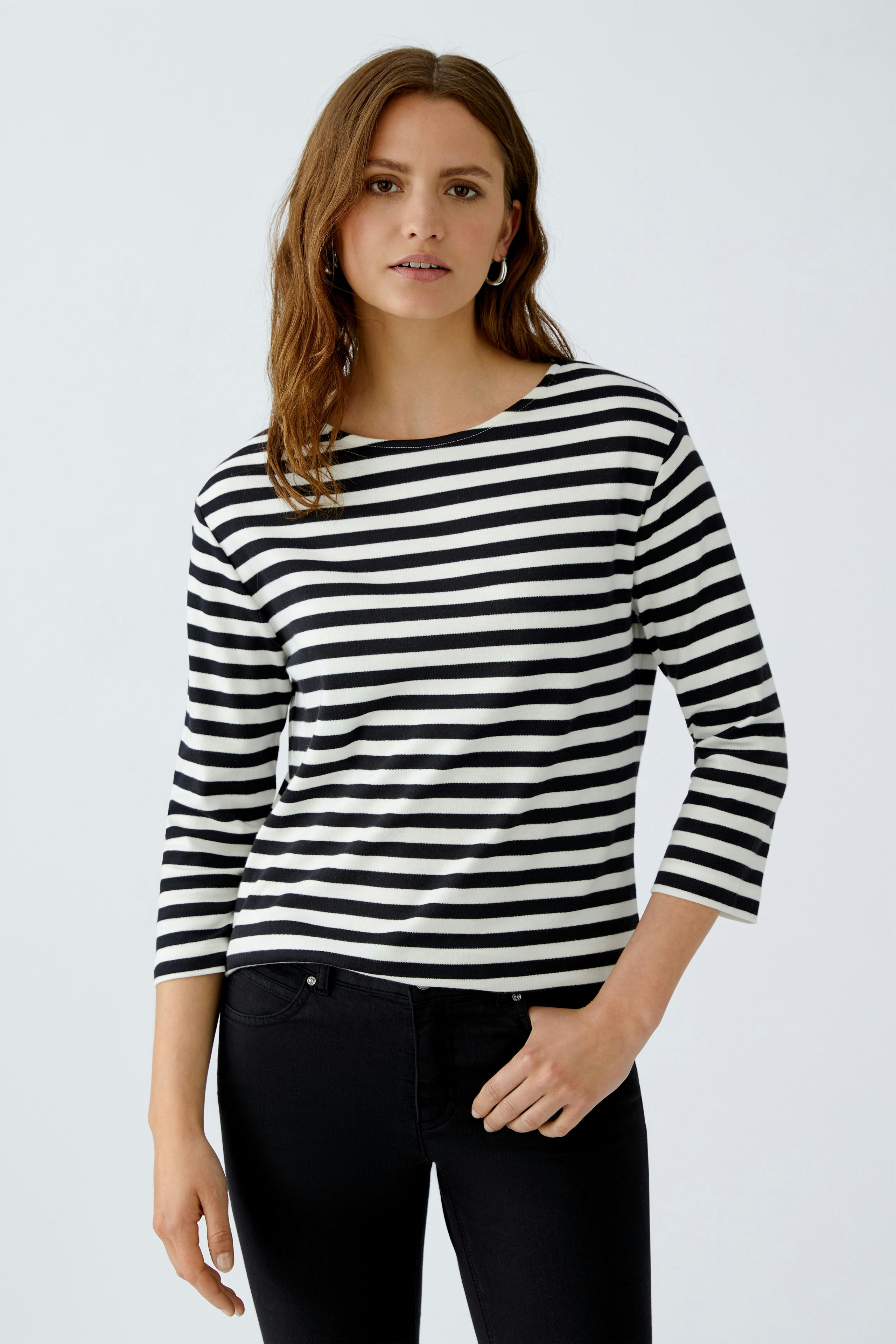 Casual women's T-shirt: Woman in a black and white striped top with three-quarter sleeves.