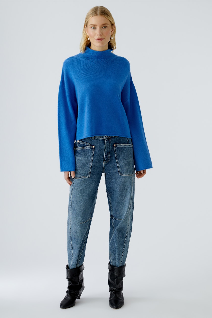 Casual women's pullover: Young woman in a blue pullover paired with relaxed-fit jeans.