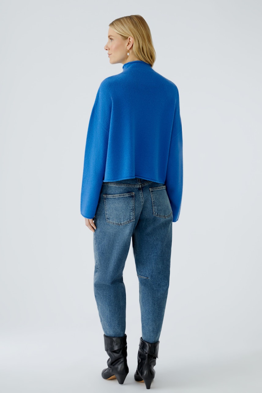 Casual women's pullover: A woman in a blue pullover paired with relaxed jeans, showcasing a modern look.