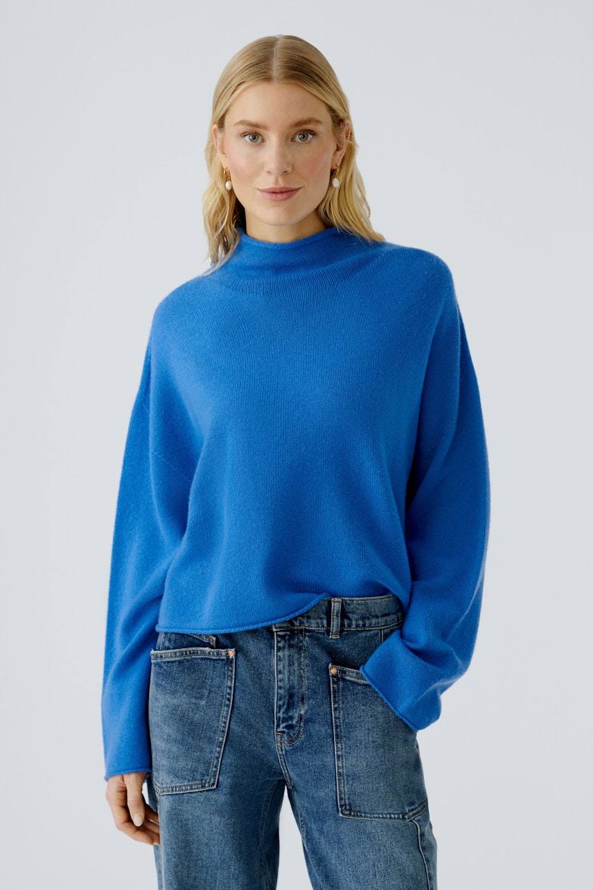 Casual women's pullover: Young woman in a blue pullover with a relaxed fit and high neckline.