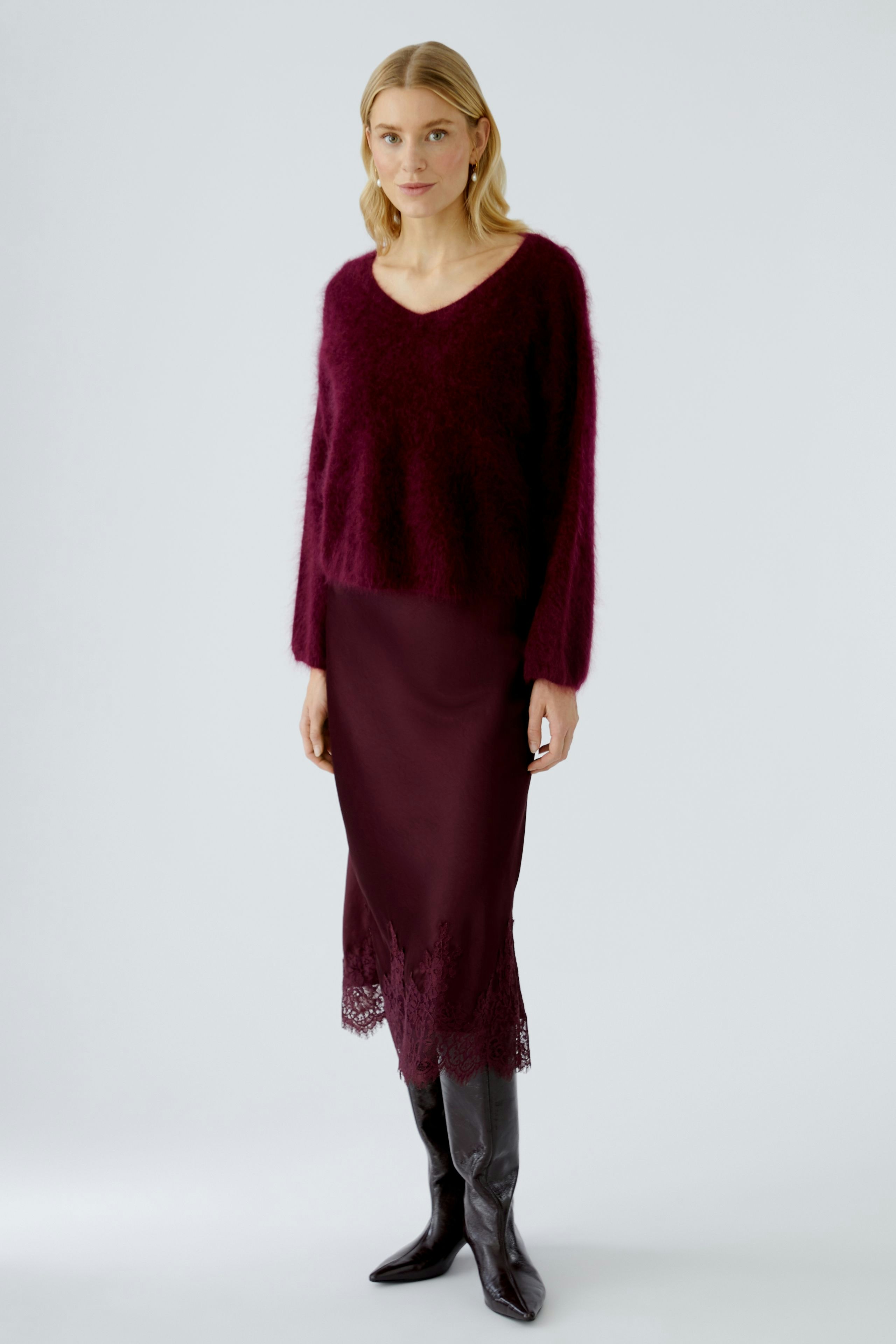 Casual women's pullover: A woman in a cozy burgundy pullover with a relaxed fit and v-neck.