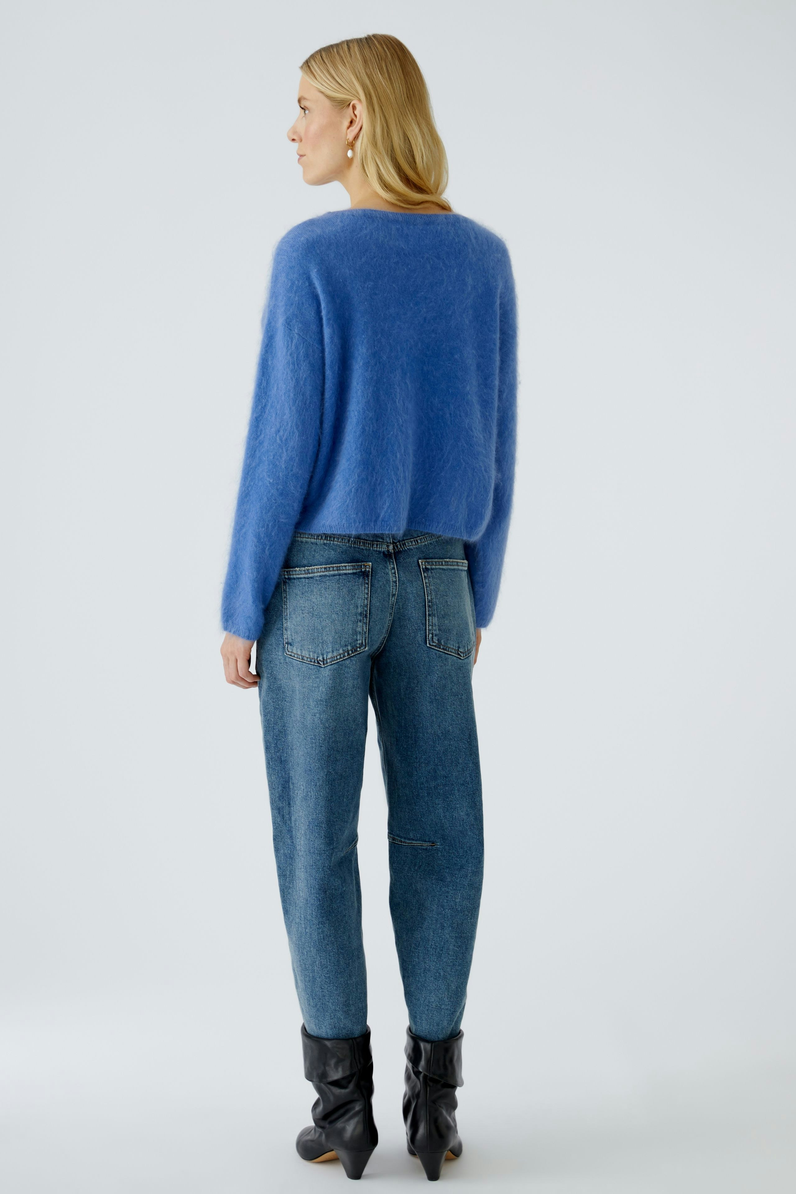 Casual women's pullover: A woman in a soft blue pullover paired with relaxed jeans.
