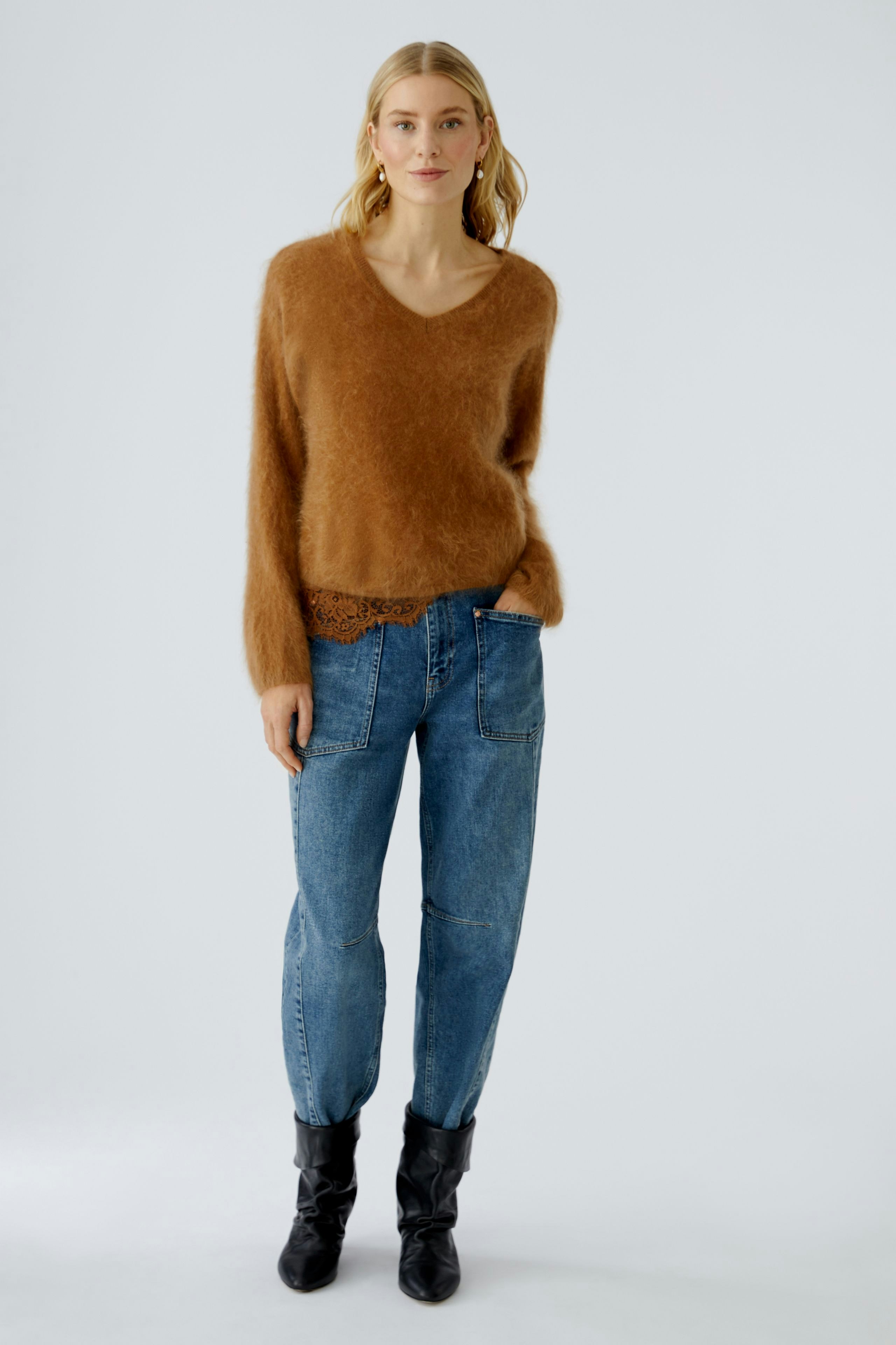 Cozy women's pullover: A woman in a soft brown pullover paired with relaxed jeans.
