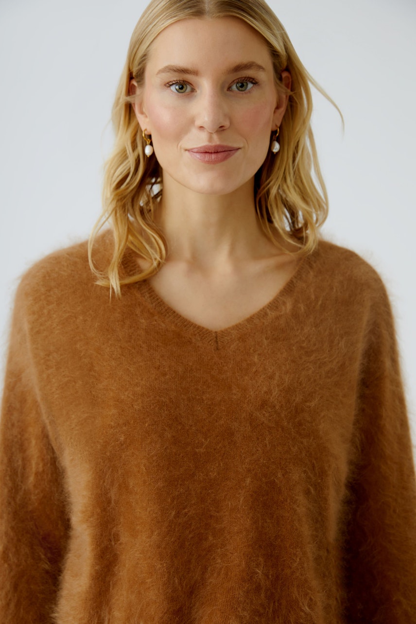 Cozy women's pullover: A woman in a soft brown V-neck pullover, radiating comfort and style.