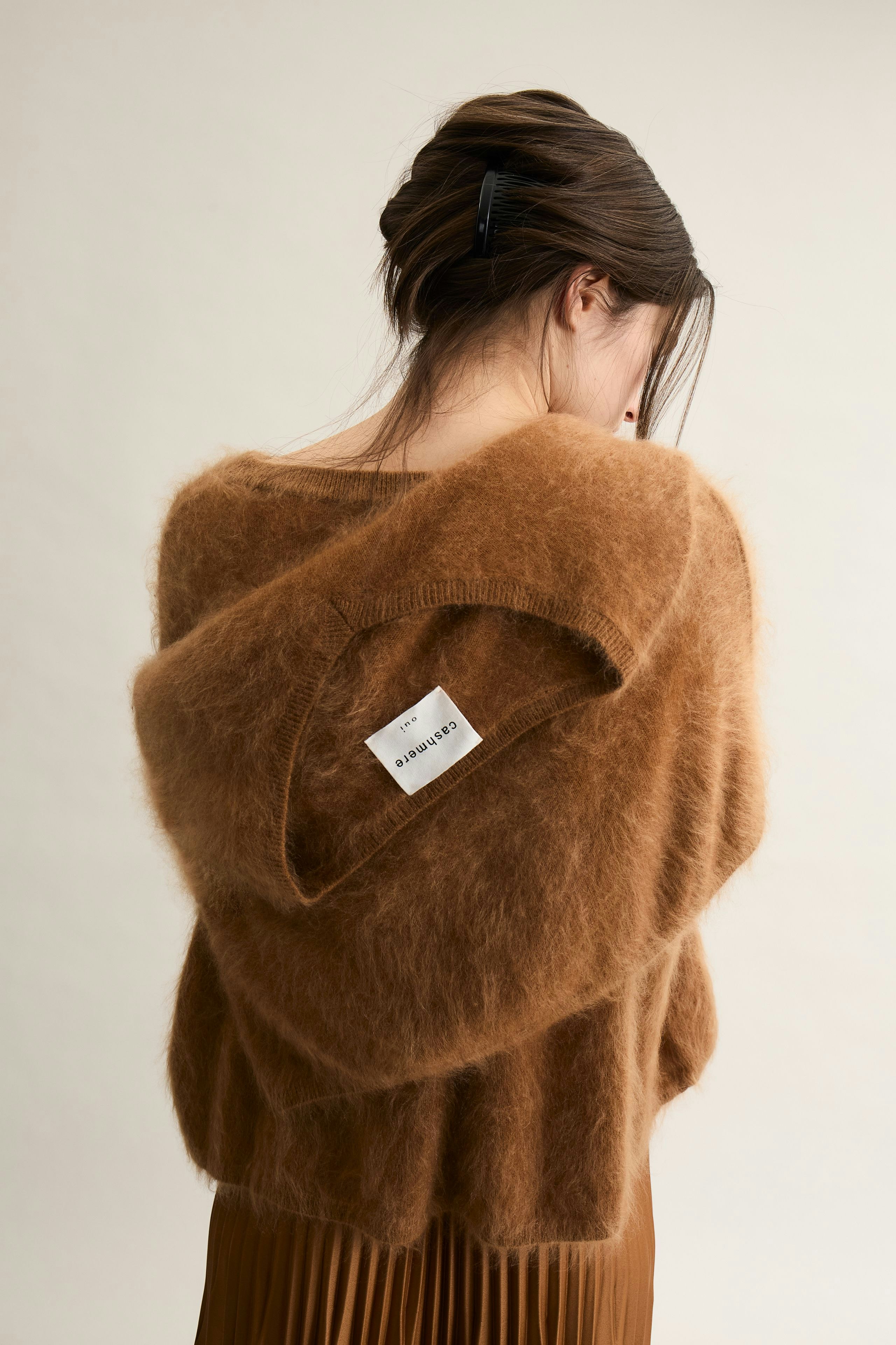 Cozy women's pullover: A woman in a soft brown pullover with a hood, showcasing a relaxed style.