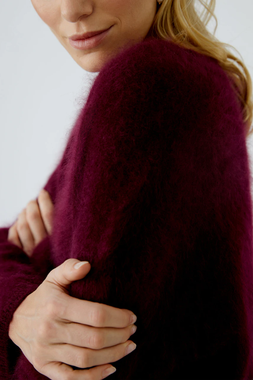 Damen-Pullover: Frau in weichem, burgunderfarbenem Strickpullover mit lässigem Schnitt und langen Ärmeln.