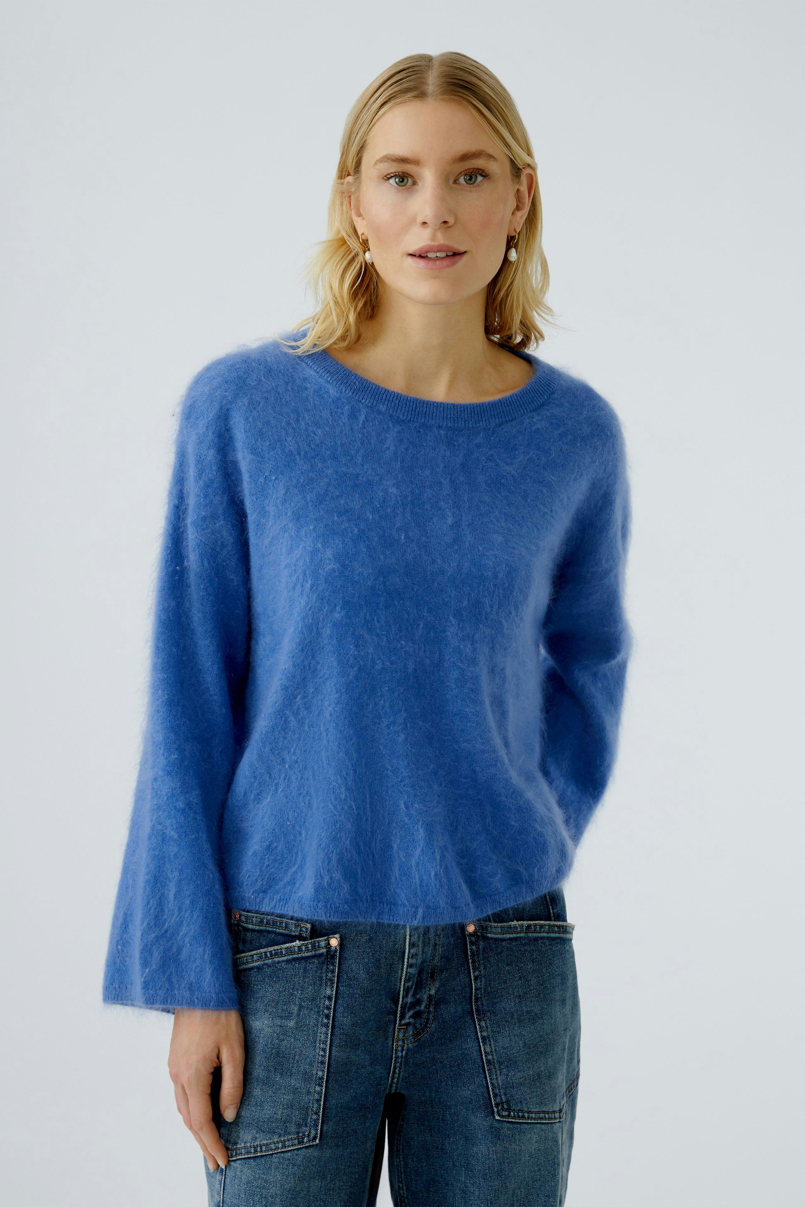Casual women's pullover: Young woman in a soft blue pullover with long sleeves and relaxed fit.