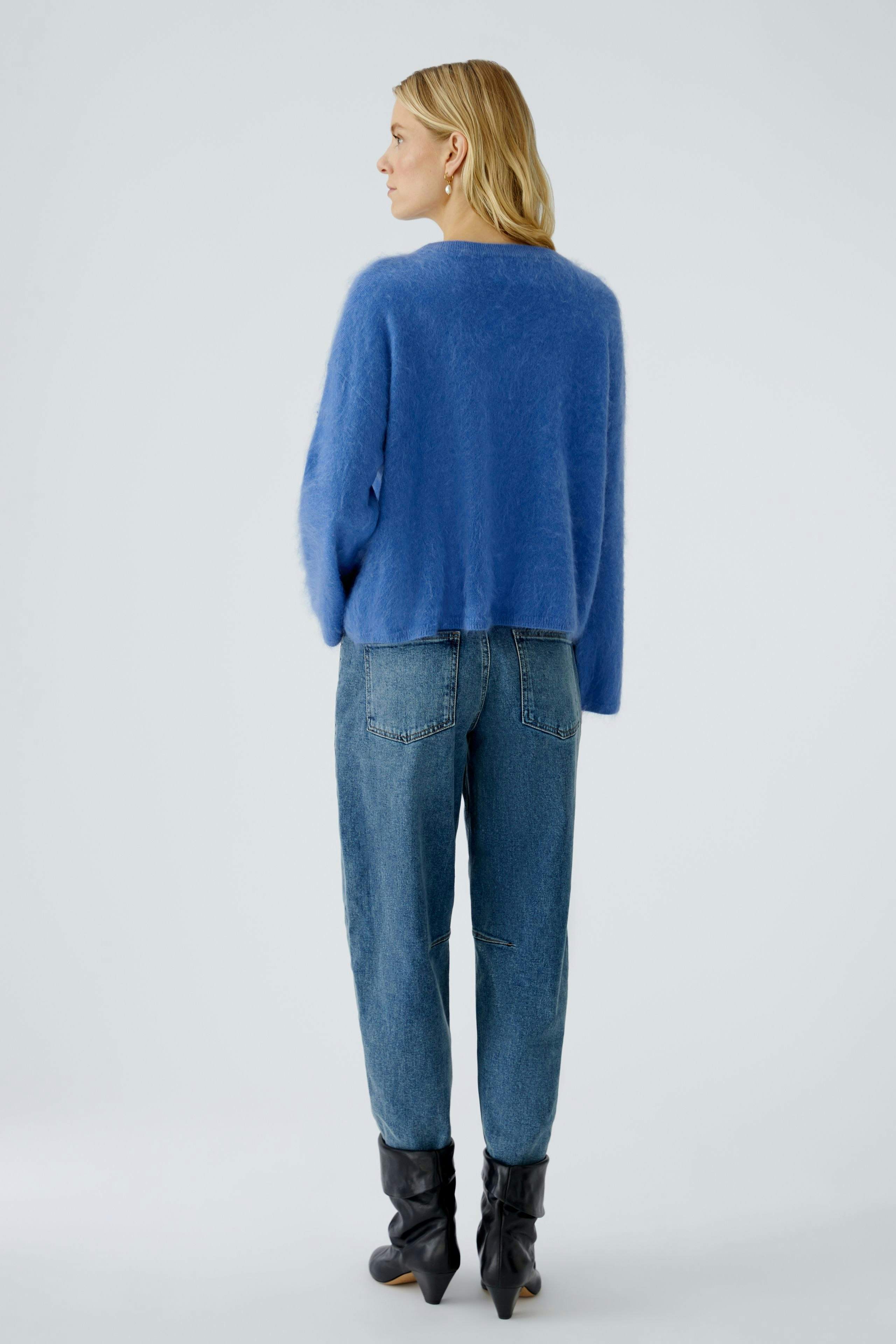 Casual women's pullover: A woman in a soft blue pullover paired with relaxed-fit jeans.