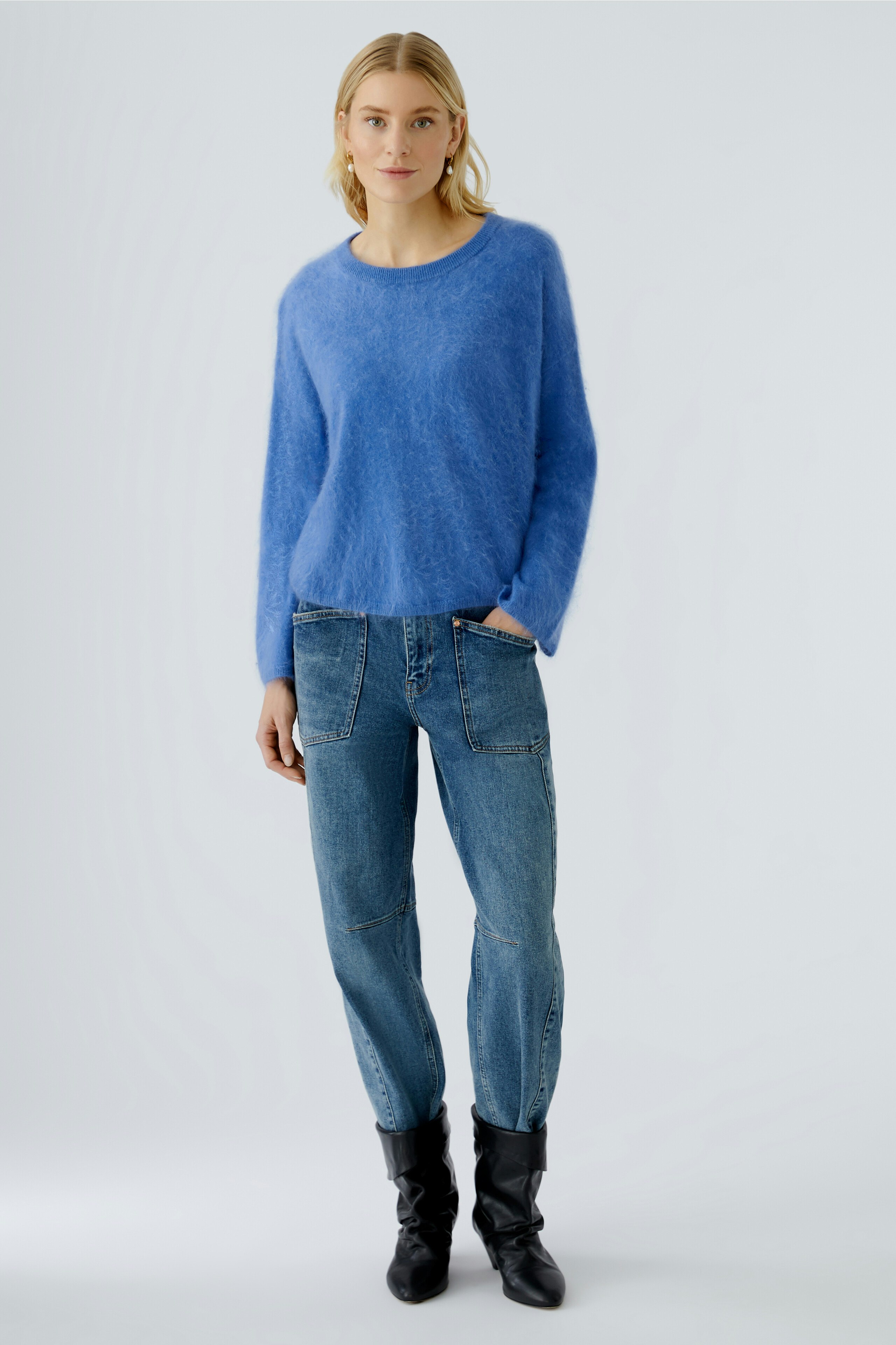 Casual women's pullover: A woman in a soft blue pullover paired with relaxed jeans.