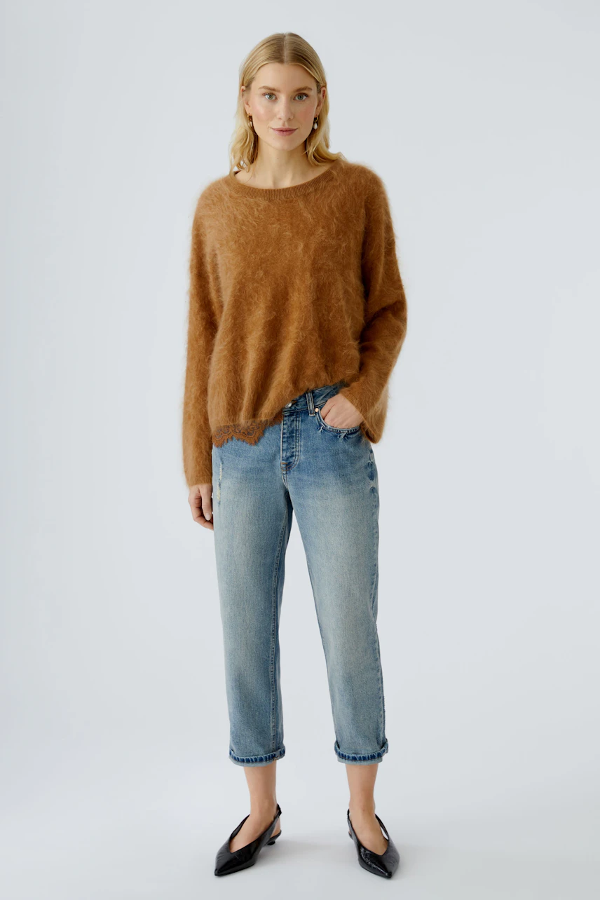 Casual women's pullover: A woman in a soft brown pullover paired with relaxed jeans.