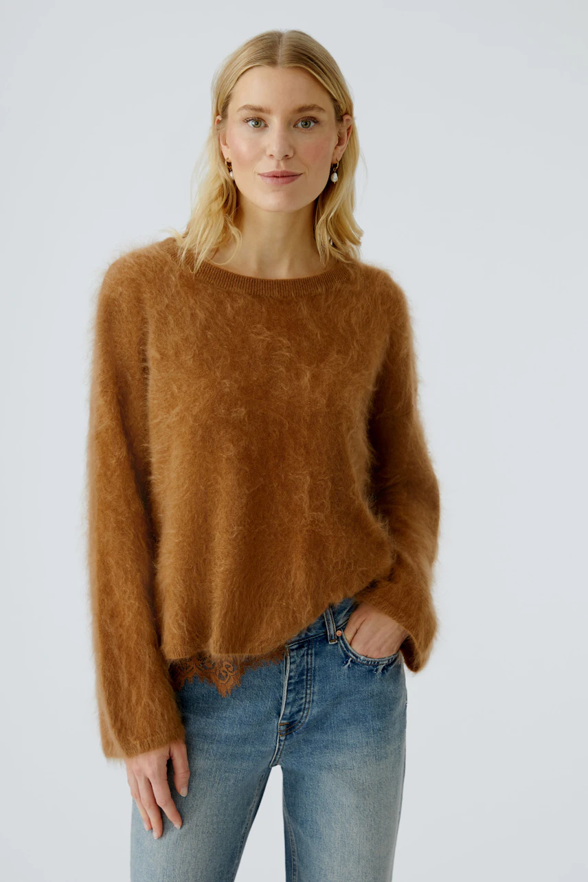 Cozy women's pullover: A woman in a soft brown pullover with a relaxed fit, paired with jeans.