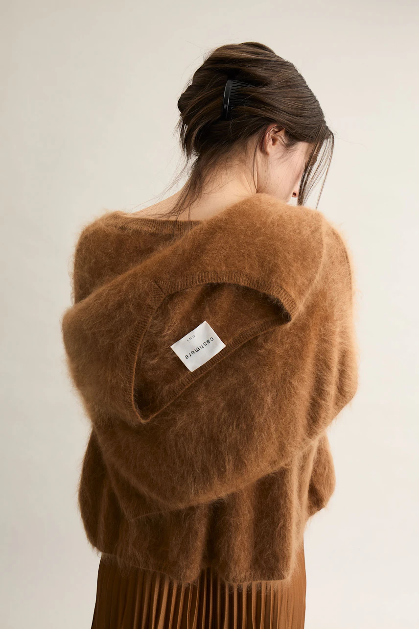 Cozy women's pullover: A woman in a soft brown pullover with a hood, showcasing a relaxed style.