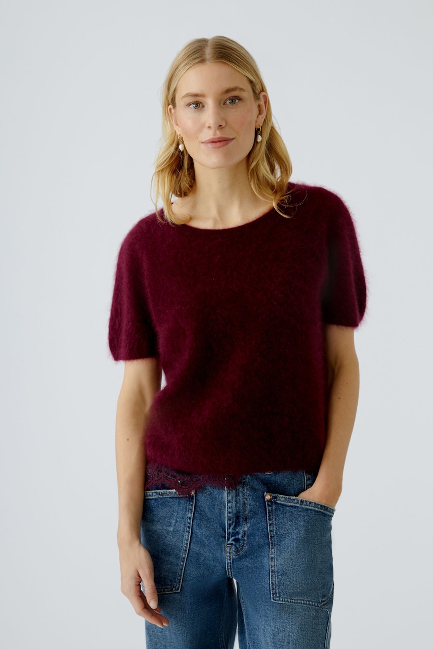 Casual women's pullover: A woman in a burgundy fluffy pullover with short sleeves and relaxed fit.