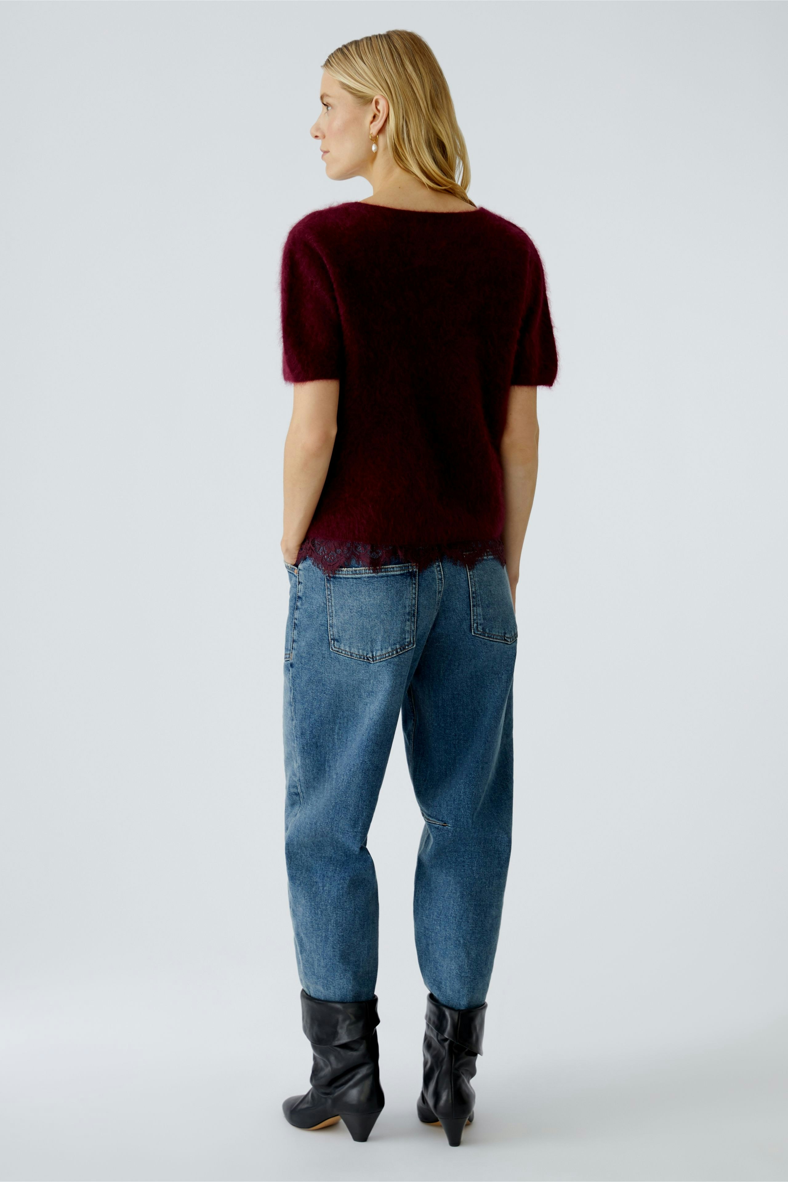 Casual women's pullover: A woman in a burgundy short-sleeve pullover paired with relaxed jeans.