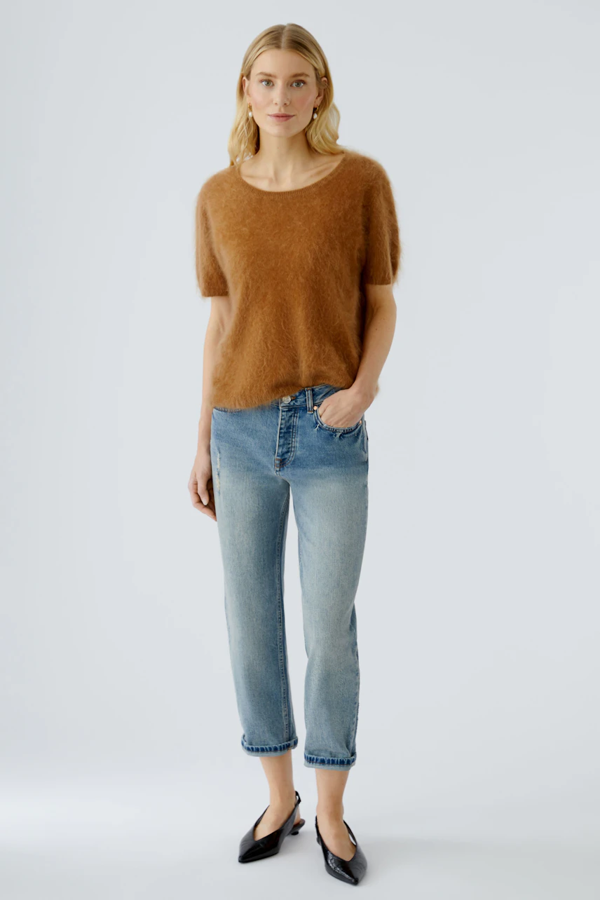 Damen-Pullover in warmem Braun, lässig geschnitten, kombiniert mit Jeans und eleganten Schuhen.