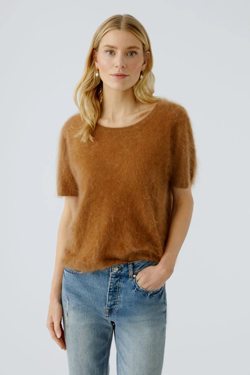 Damen-Pullover: Junge Frau in einem braunen, lässigen Pullover mit kurzen Ärmeln und lockerer Passform.