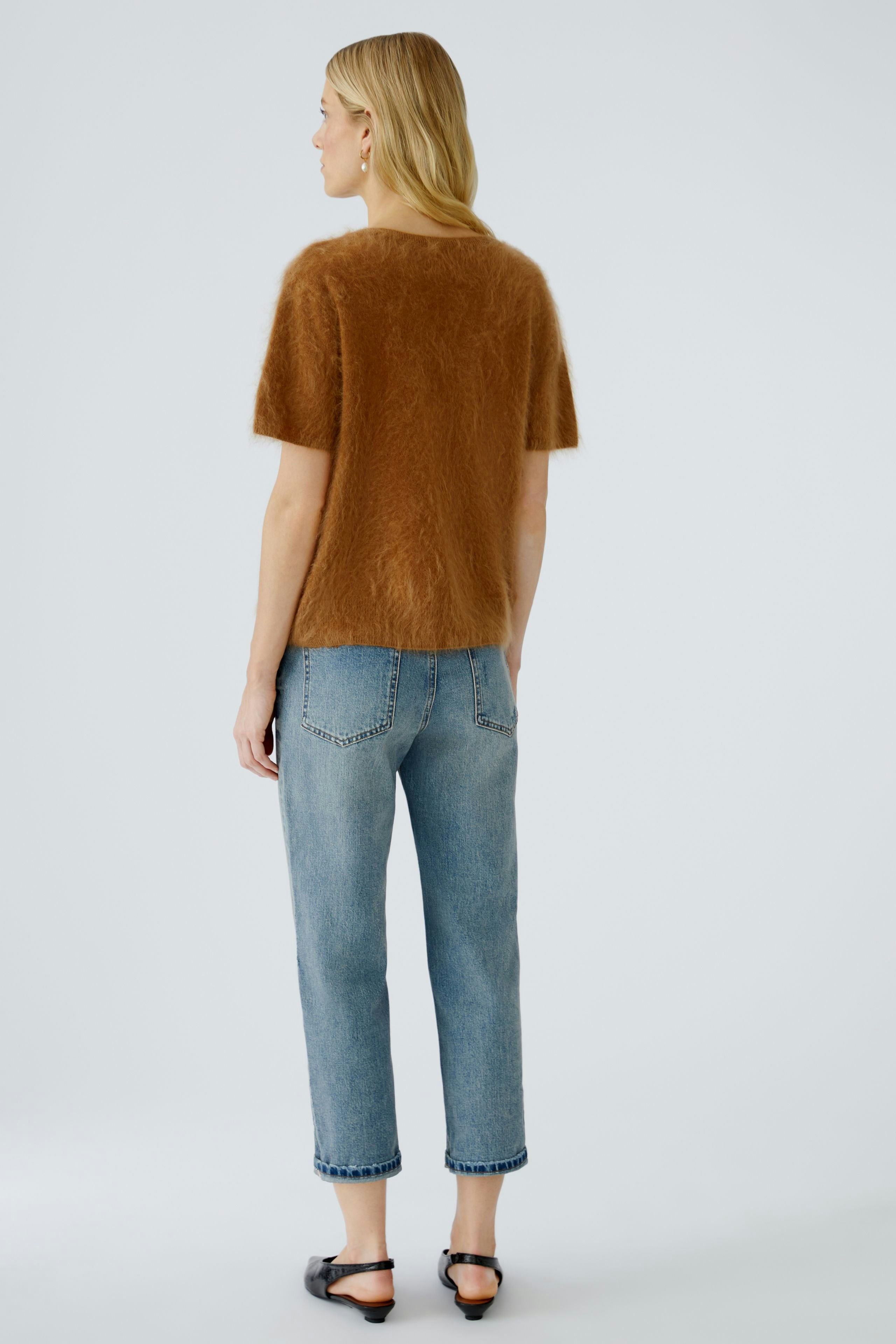 Casual women's pullover: A woman in a soft brown pullover paired with relaxed jeans.