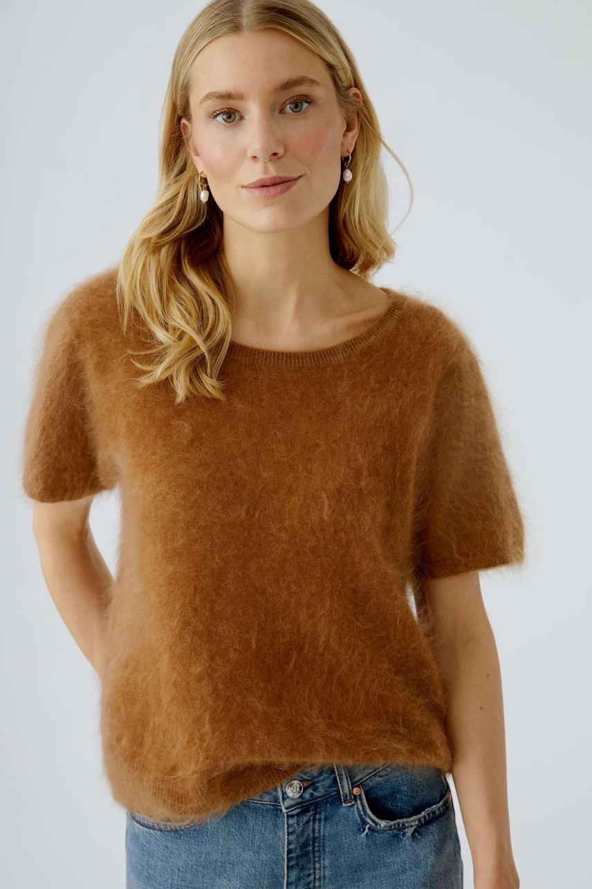 Damen-Pullover: Junge Frau trägt einen braunen, flauschigen Pullover mit kurzen Ärmeln und lässiger Passform.