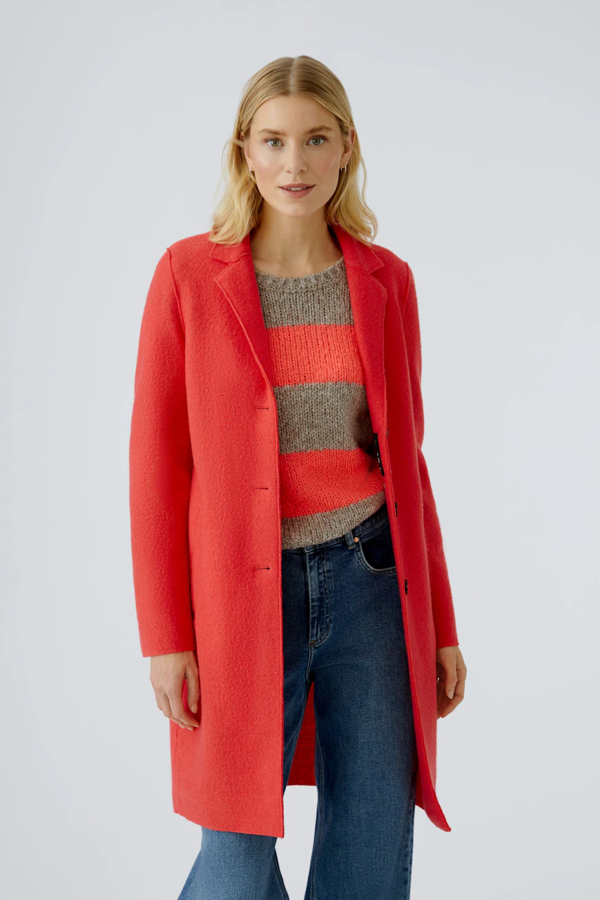 Damen-Wollmantel in leuchtendem Rot, kombiniert mit gestreiftem Pullover und Jeans.
