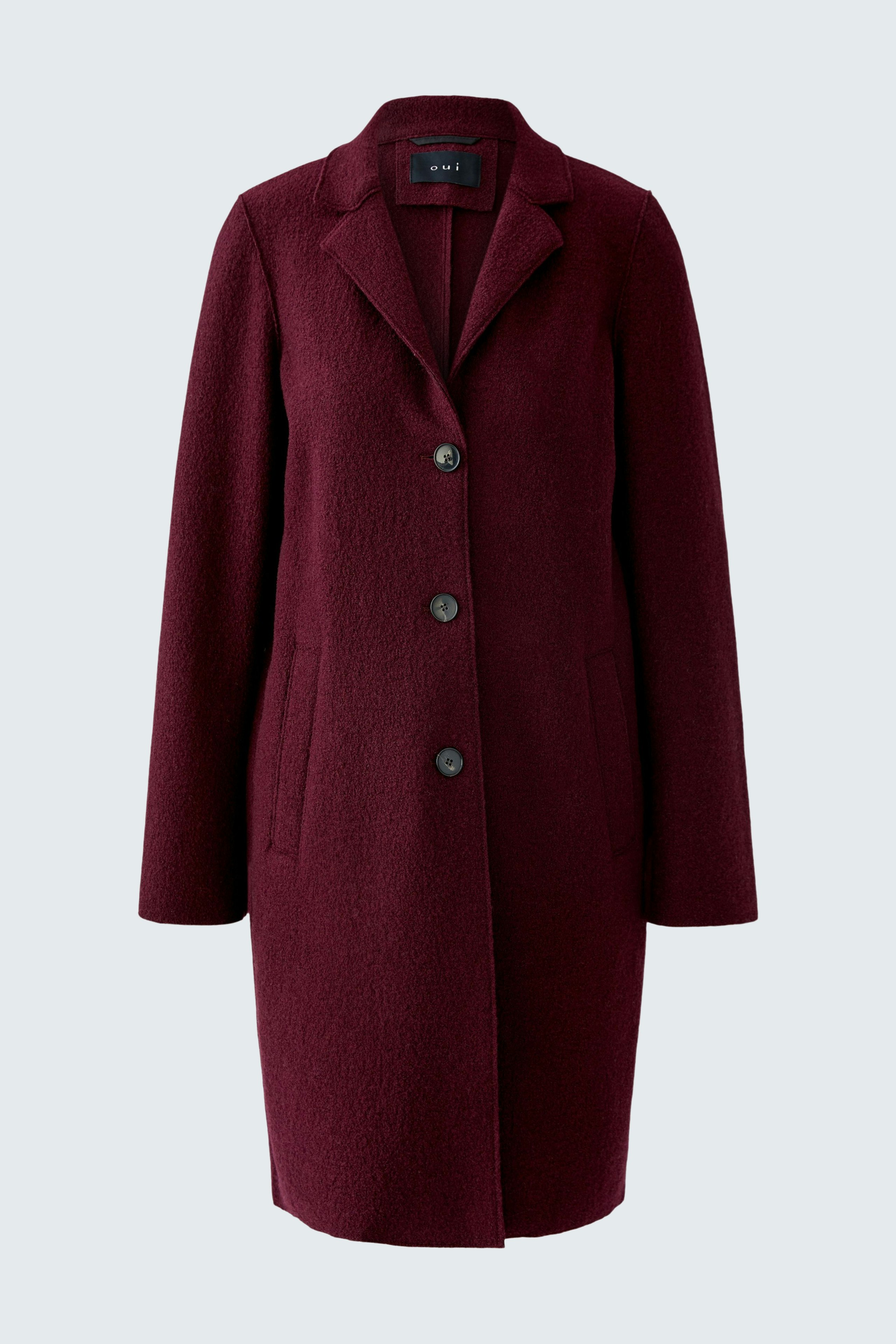Wool coat: A woman in a burgundy wool coat with a classic collar and button closure.