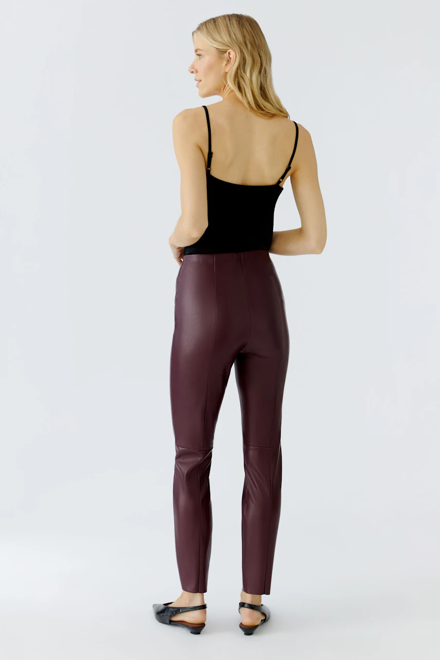 Stylish women's leggings in burgundy, paired with a black top, showcasing a modern look.