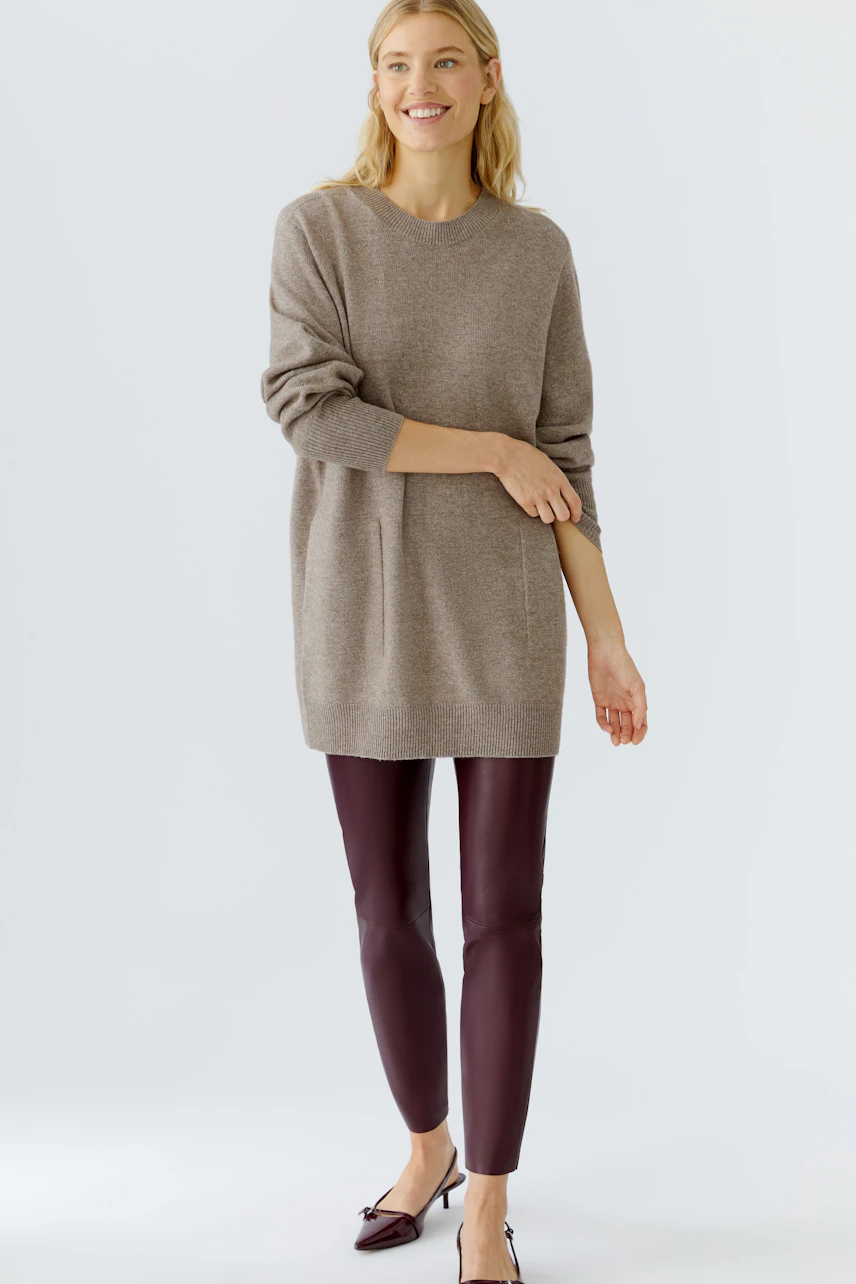 Comfortable leggings: Woman in burgundy leggings paired with a cozy oversized pullover.