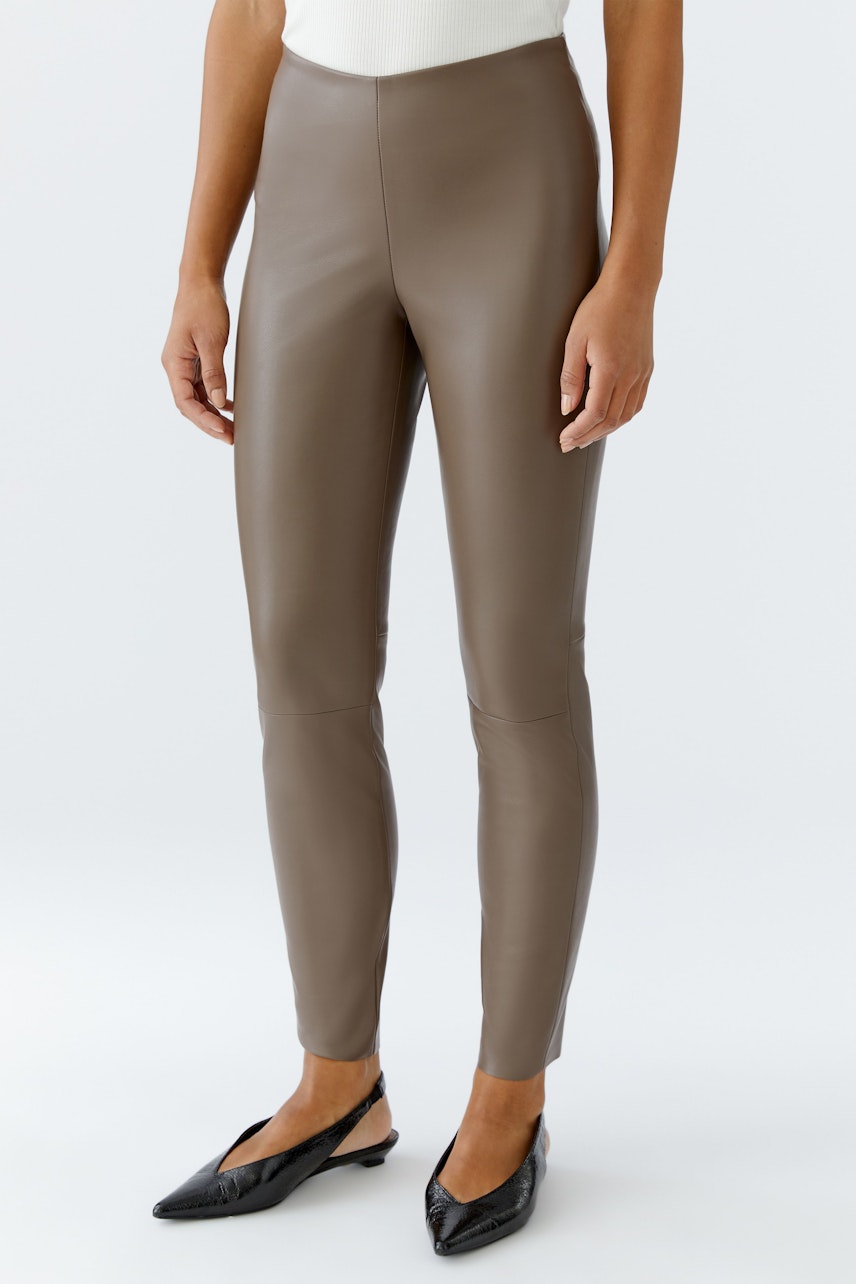 Moderne Damen-Leggings: Frau in braunen, figurbetonten Leggings mit schmalem Schnitt.