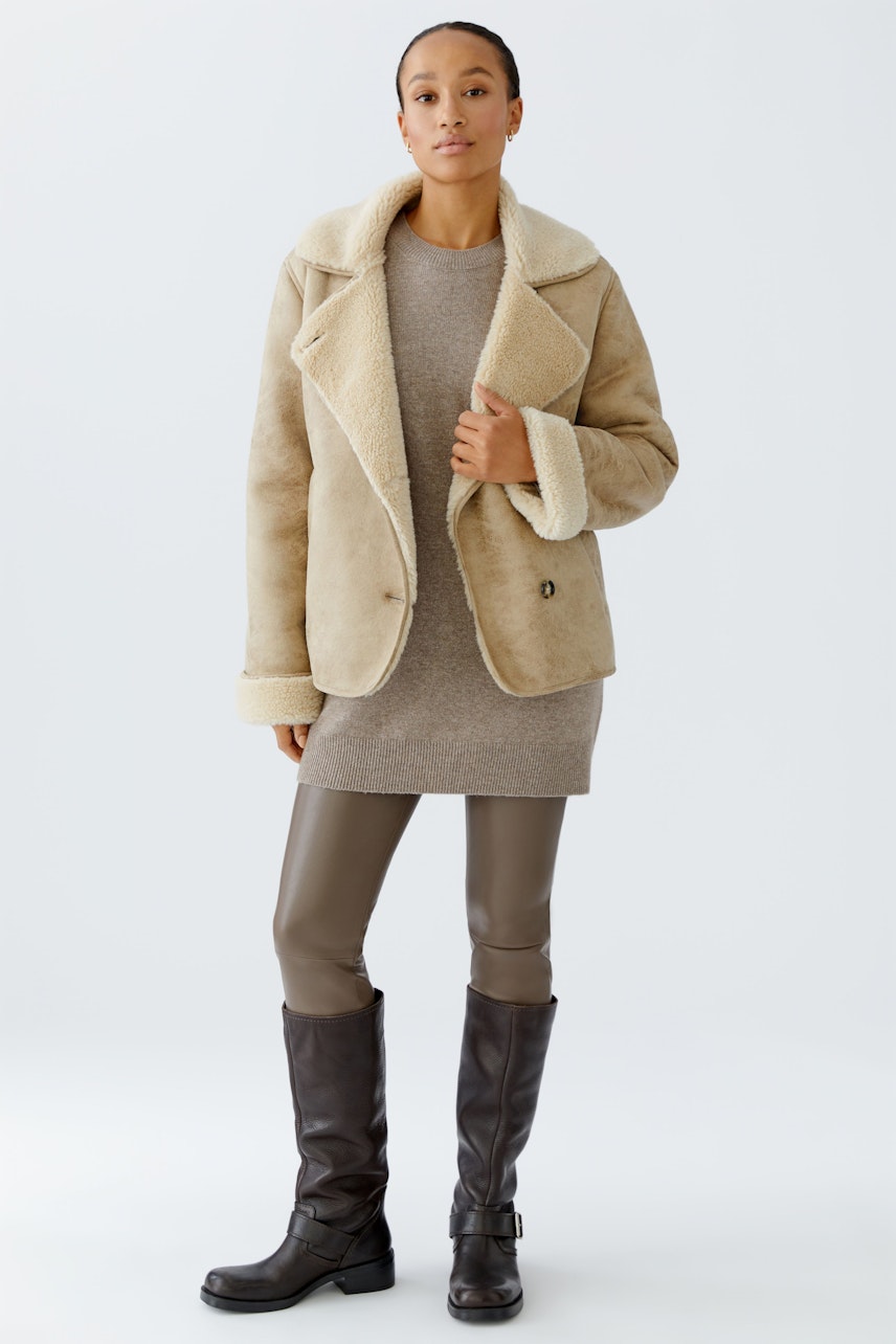 Bequeme Damen-Leggings: Frau in grauen Leggings und lässiger Jacke steht selbstbewusst.