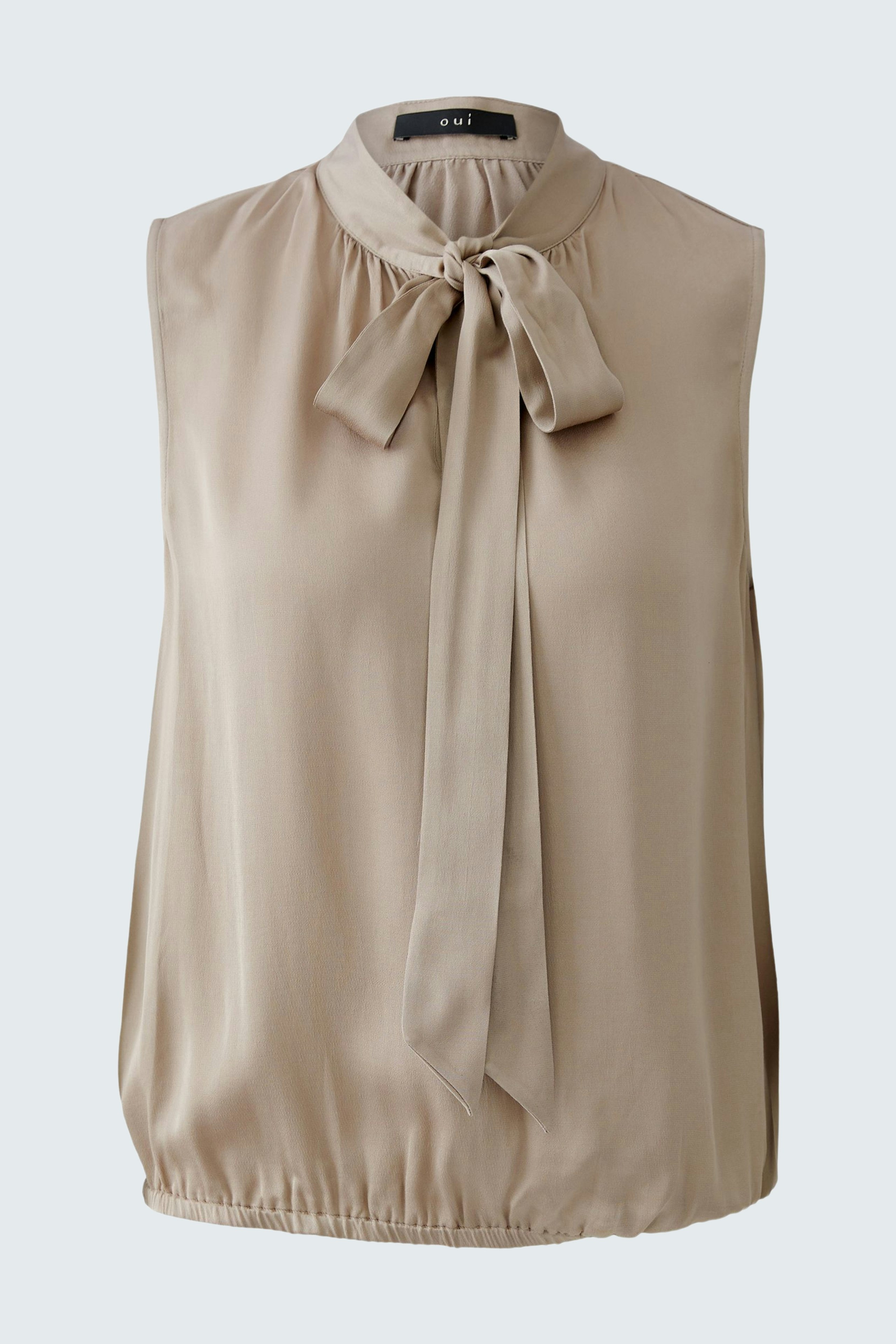 Light beige blouse with a bow tie detail, perfect for casual wear.