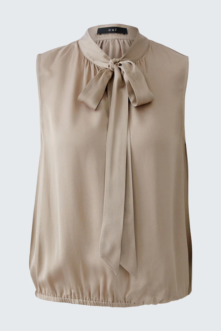 Light beige blouse with a bow tie detail, perfect for casual wear.