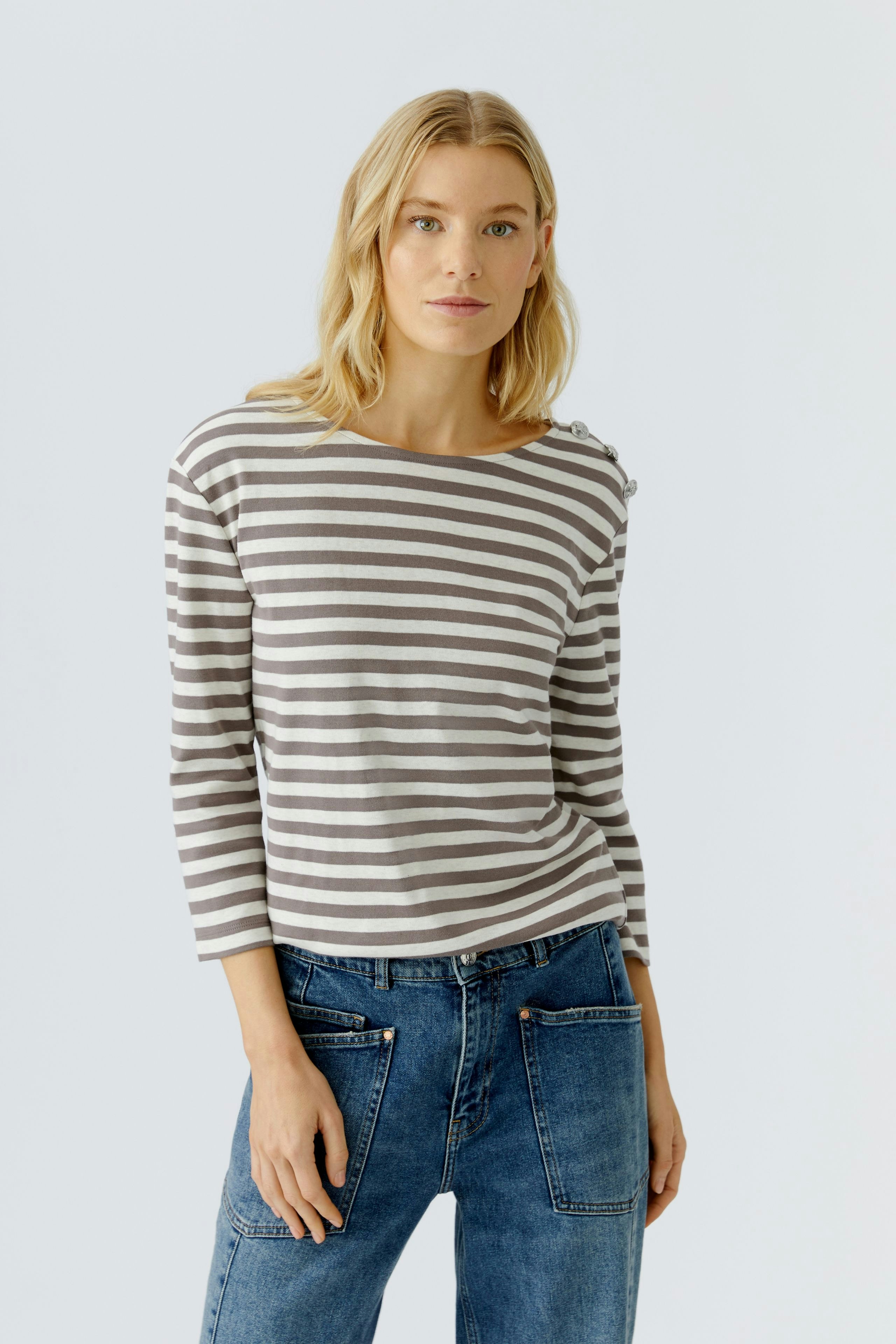 Damen Langarmshirt: Frau in gestreiftem Shirt mit Rundhalsausschnitt und lässiger Jeans.