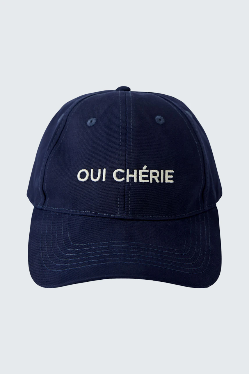Casual navy cap with 'OUI CHÉRIE' lettering, perfect for everyday wear.