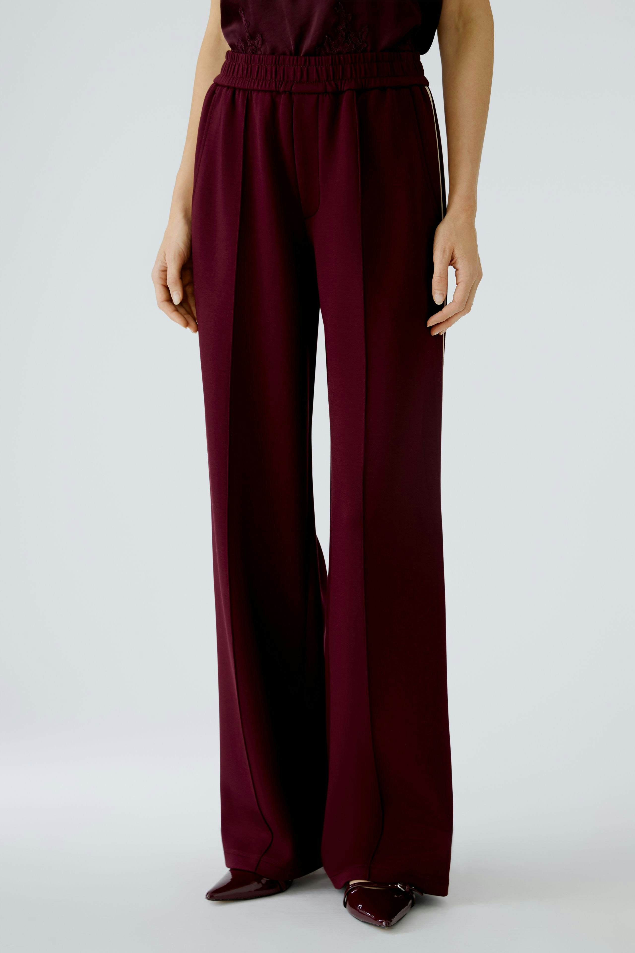 Comfortable women's joggers in deep burgundy, featuring a relaxed fit and elastic waistband.