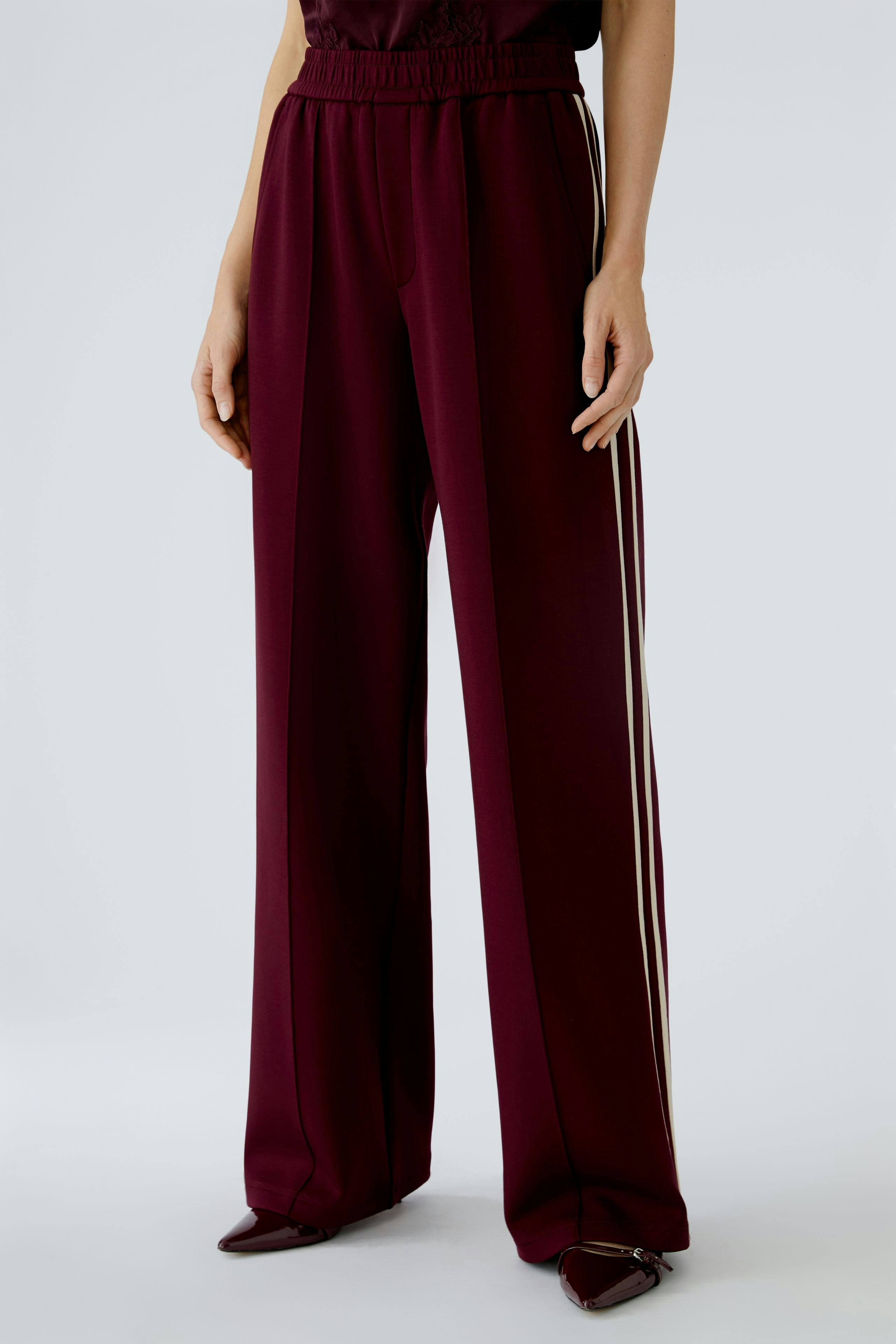 Comfortable women's joggers in burgundy with side stripes, perfect for casual wear.