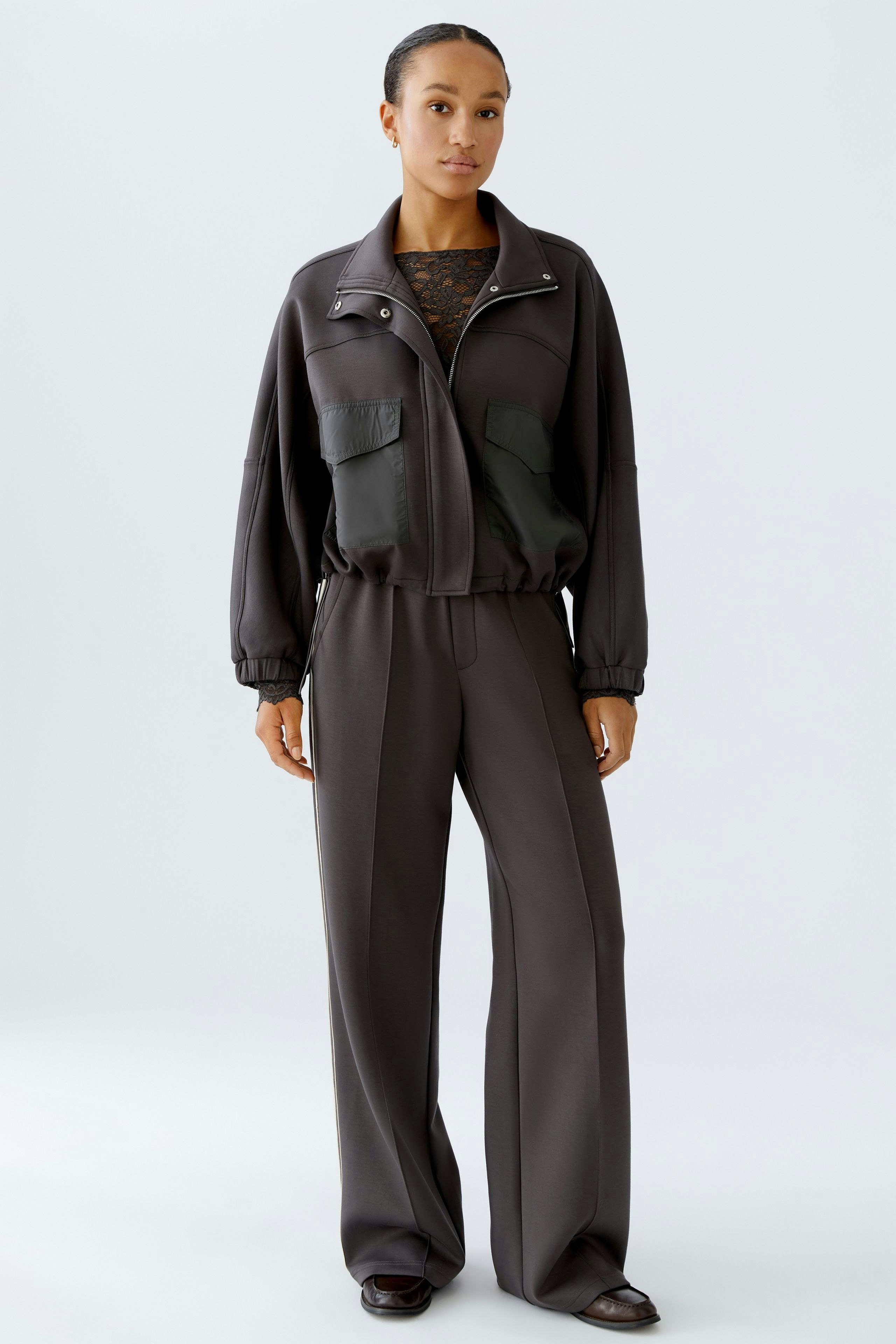 Bequeme Damen-Jogger: Frau in lässigen, grauen Jogginghosen mit passender Jacke und sportlichem Look.