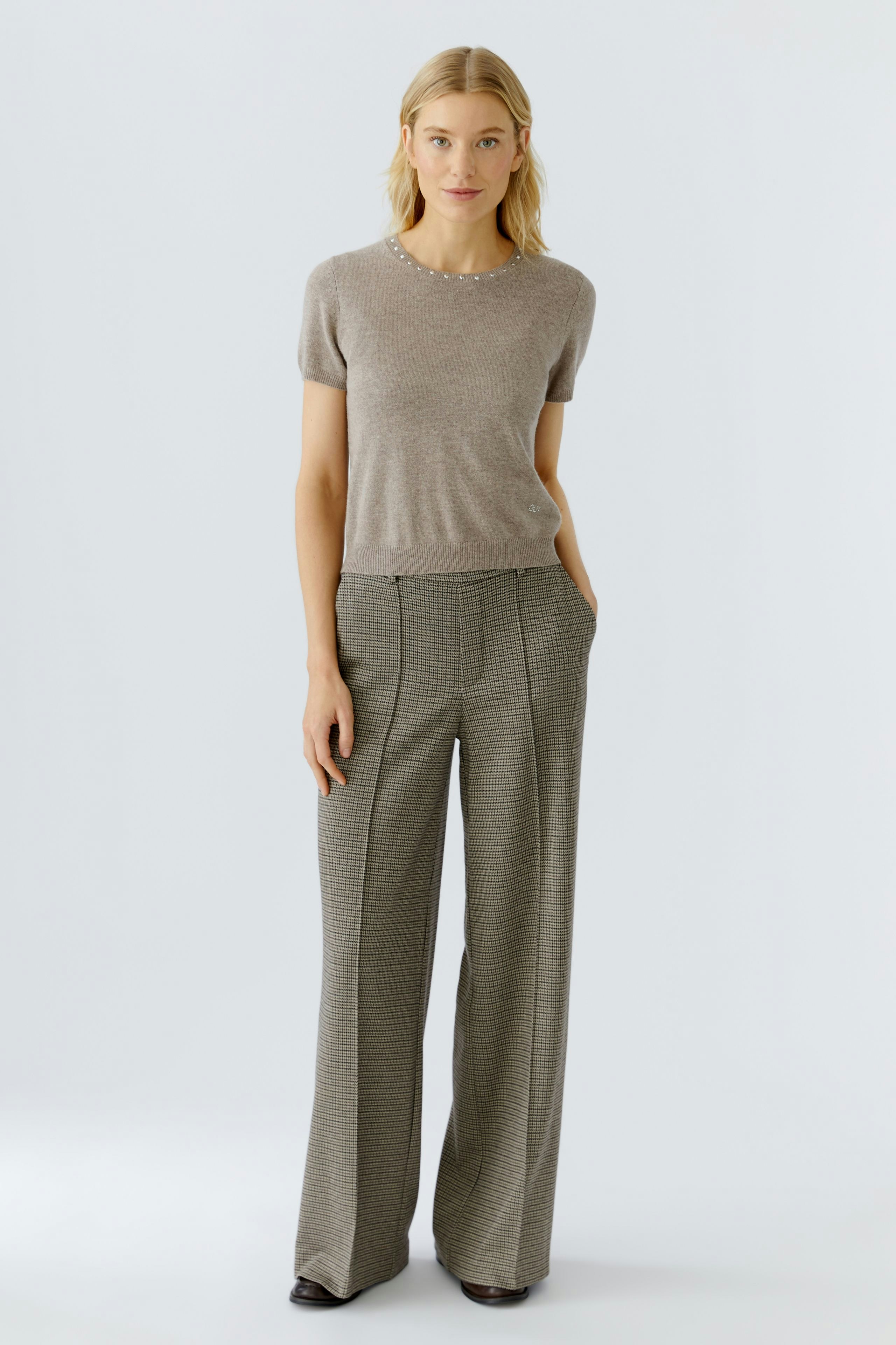 Casual women's pullover: A woman in a light brown pullover with short sleeves and a relaxed fit.