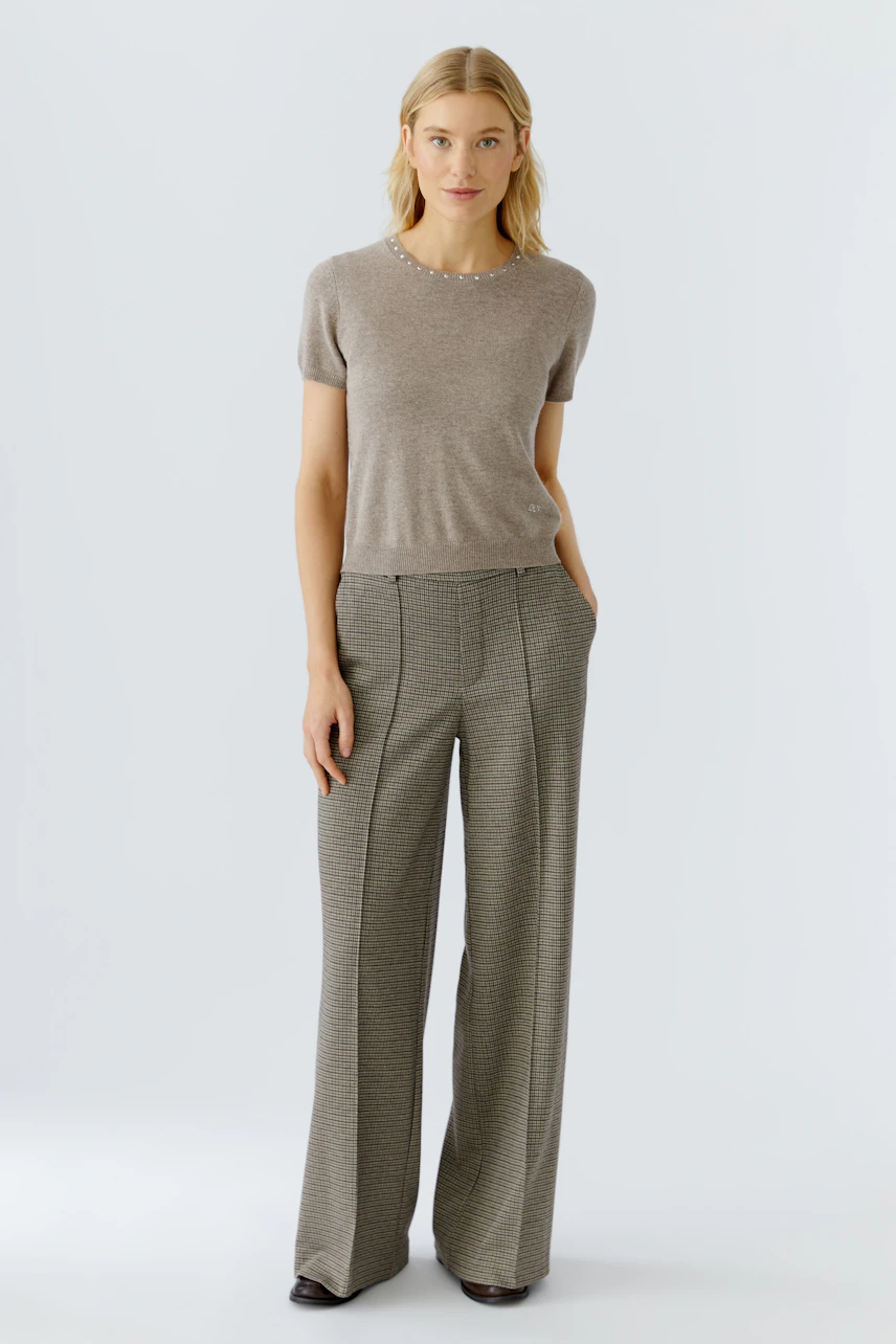 Beiger Damen-Pullover: Frau trägt einen schlichten, kurzärmeligen Pullover mit Rundhalsausschnitt.